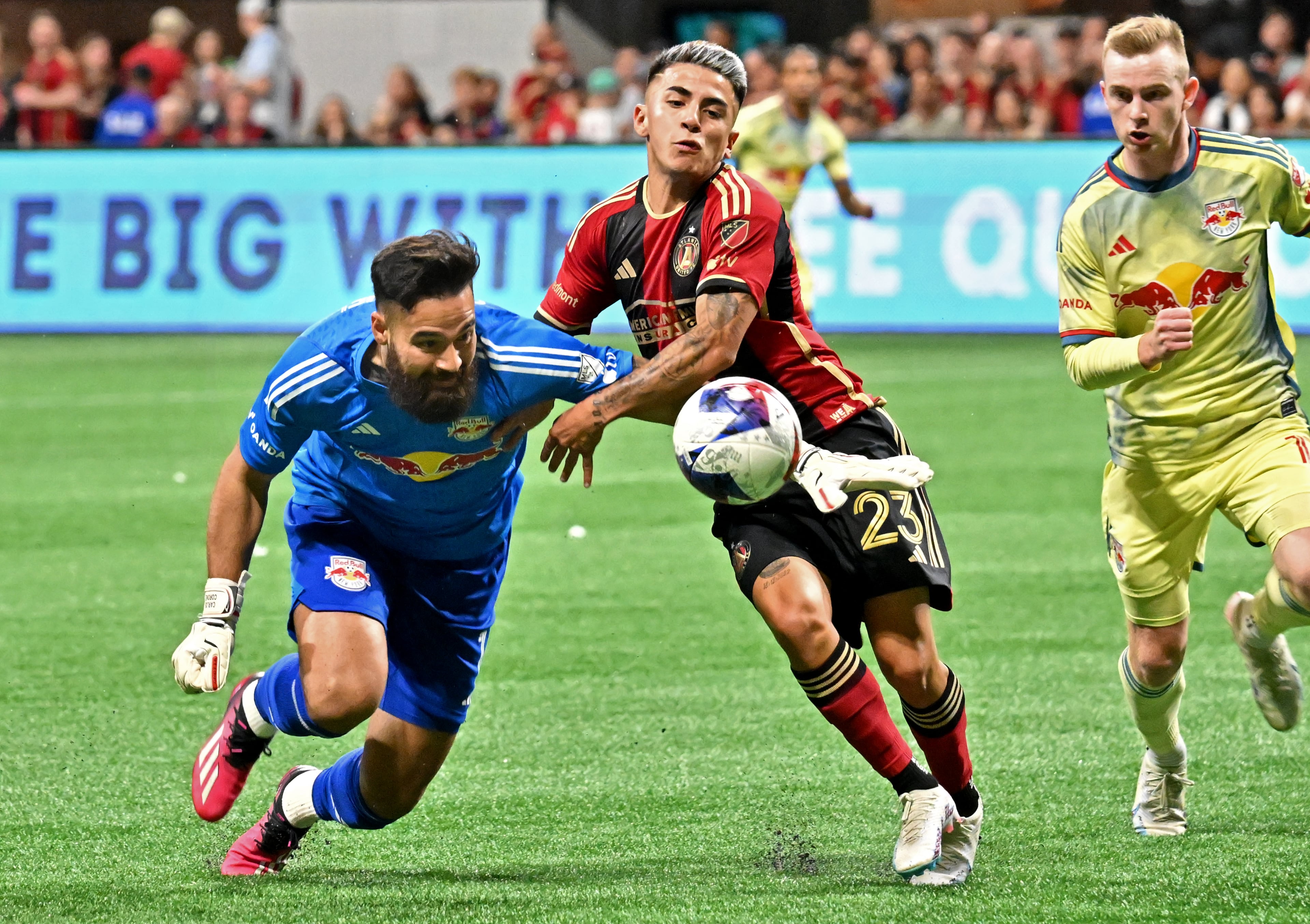 Atlanta United's midfielder Thiago Almada (23) battles New York Red Bulls' goalkeeper Carlos Miguel Coronel (left). (Hyosub Shin / Hyosub.Shin@ajc.com)