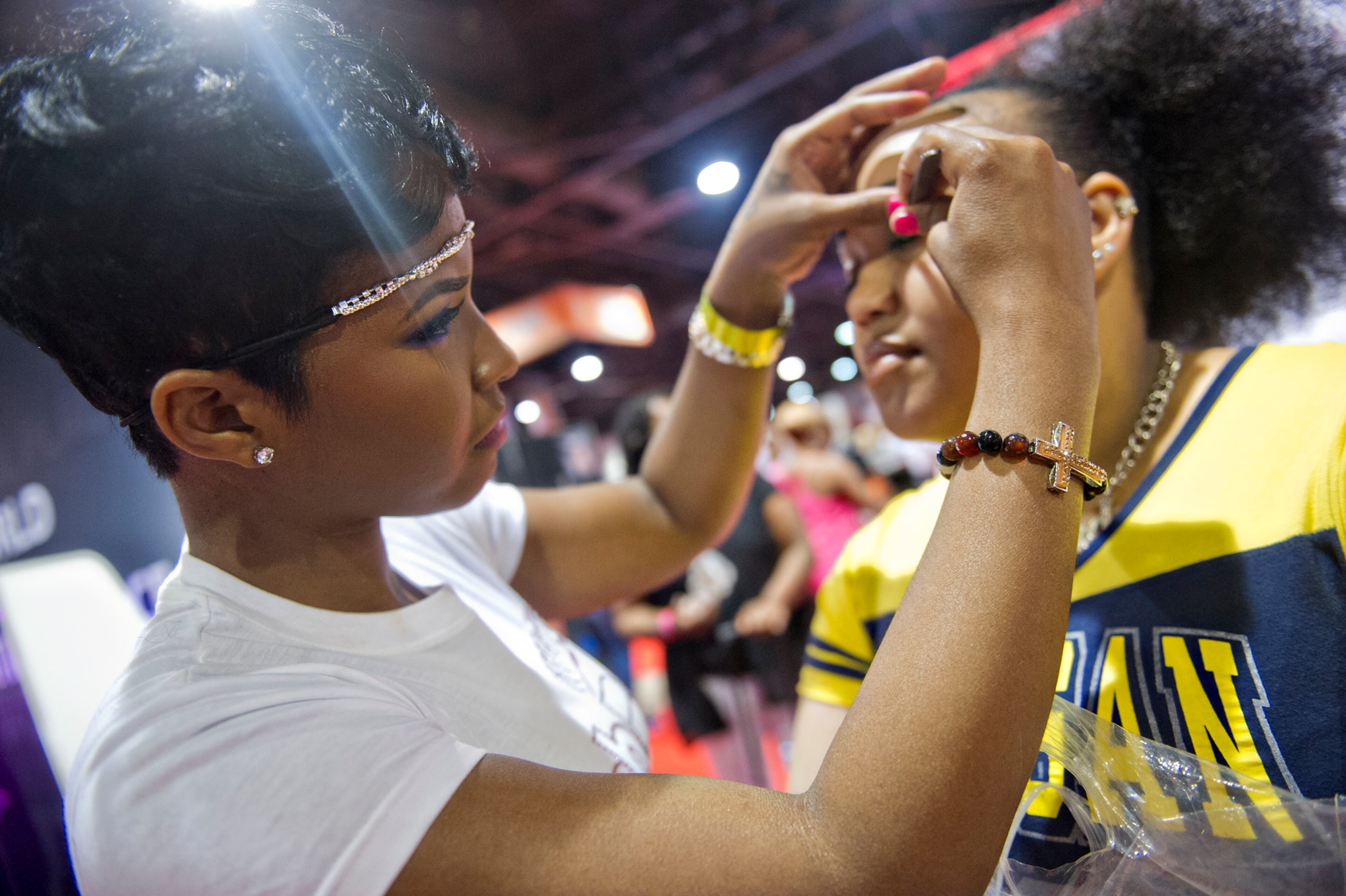 Joyua Gibson (left) applies lashes to Kanisha Brewer's eyelids during the Bronner Bros. International Hair Show at the Georgia World Congress Center in Atlanta on Saturday, August 2, 2014. JONATHAN PHILLIPS / SPECIAL