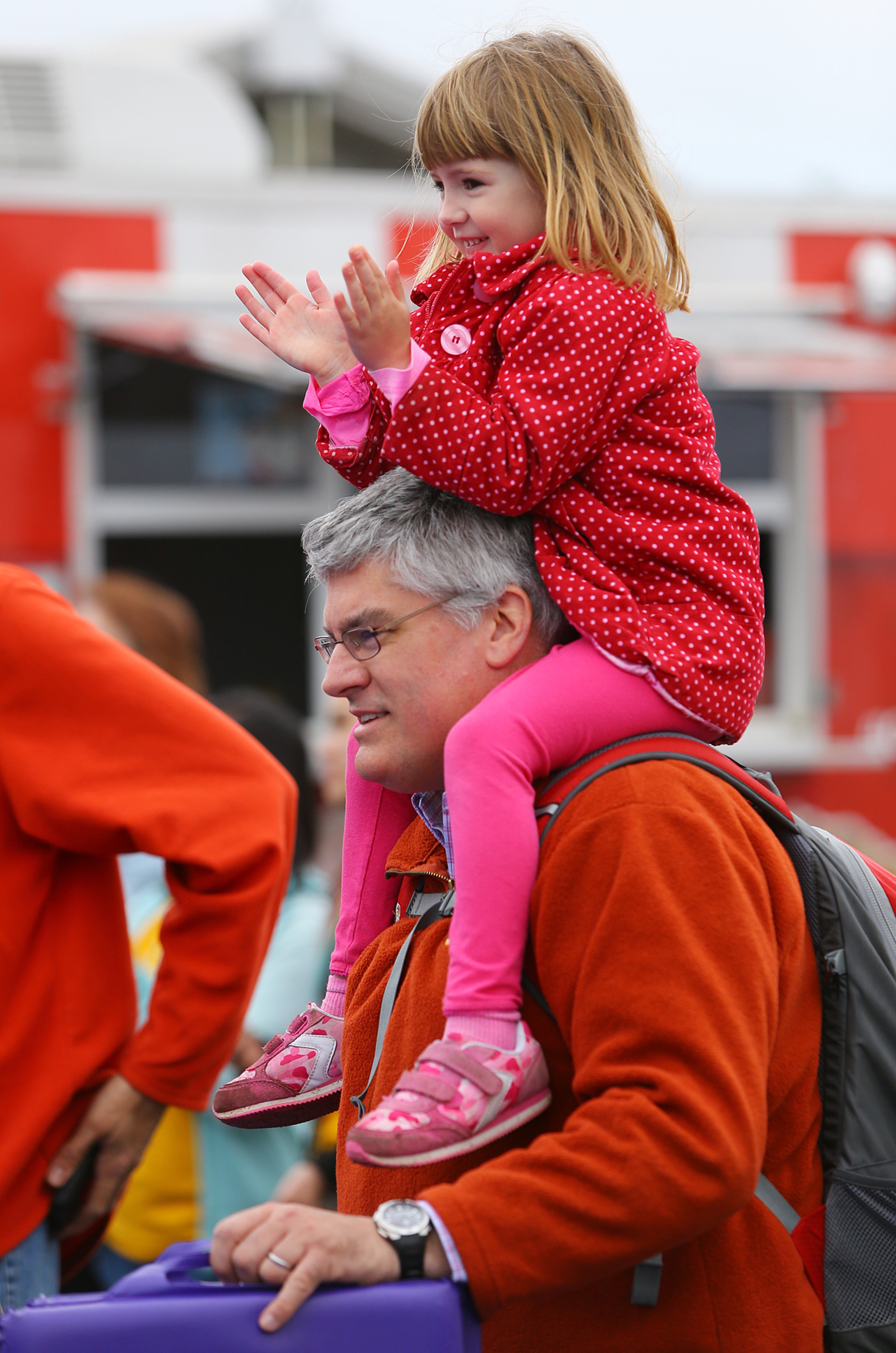 Colette Dickerson, 4, gives UMAS Karate some applause taking in their martial arts demo from the vantage point of her father Andrew Dickerson's shoulders at the 33rd Annual Conyers Cherry Blossom Festival on Sunday, March 23, 2014, in Conyers.