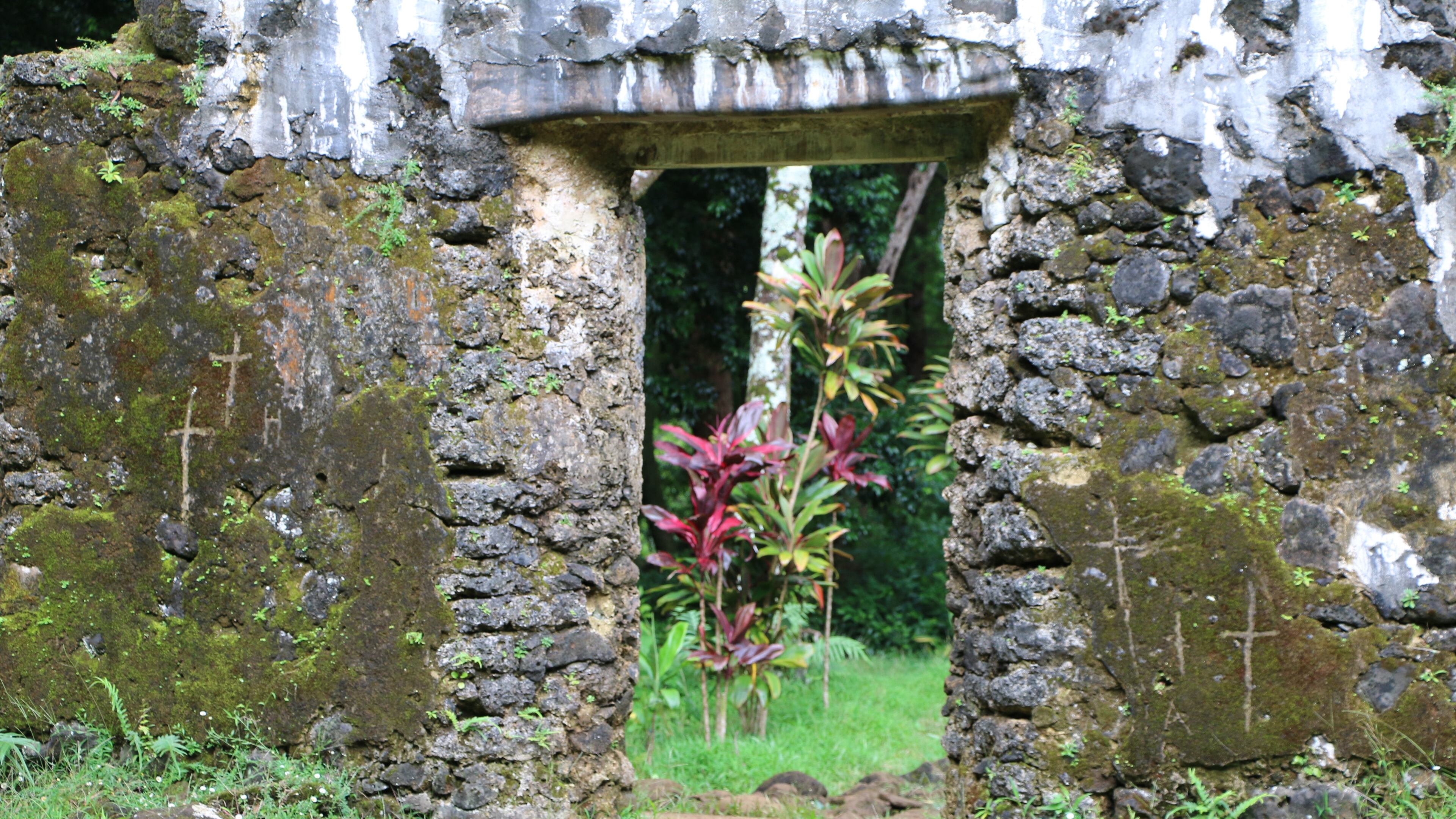 This undated photo, provided by the Hawaii Department of Land and Natural Resources, shows crosses etched by vandals on the crumbling remains of the 180-year-old summer palace of former King Kamehameha III in the forest of a Honolulu, Hawaii, neighborhood. The Department said Thursday, June 23, 2016, that unless the vandals are caught desecrating the sacred cultural site, there’s little law enforcement officers can do. (Hawaii Department of Land and Natural Resources via AP)