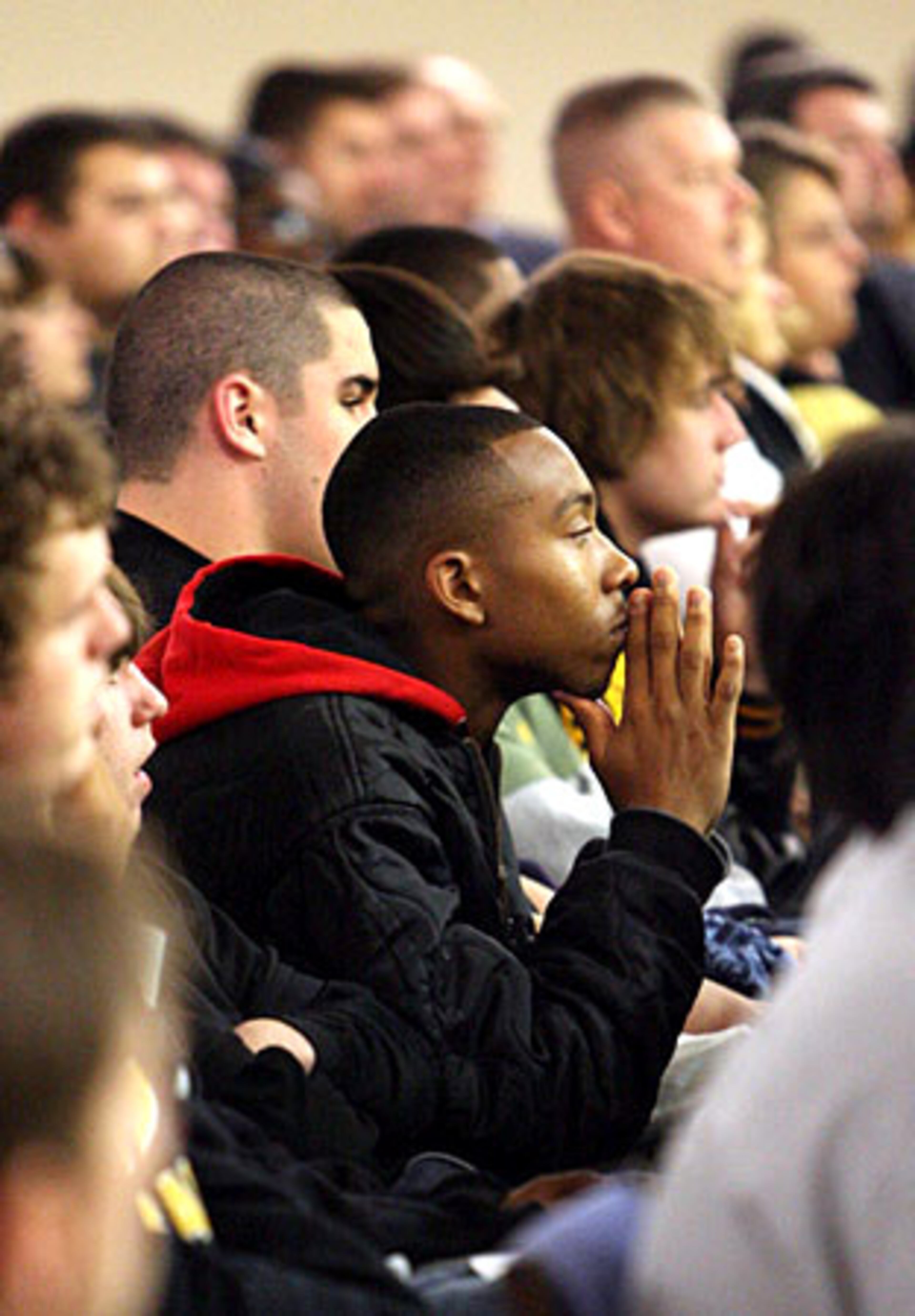 A Central Gwinnett football player listens during the memorial service.