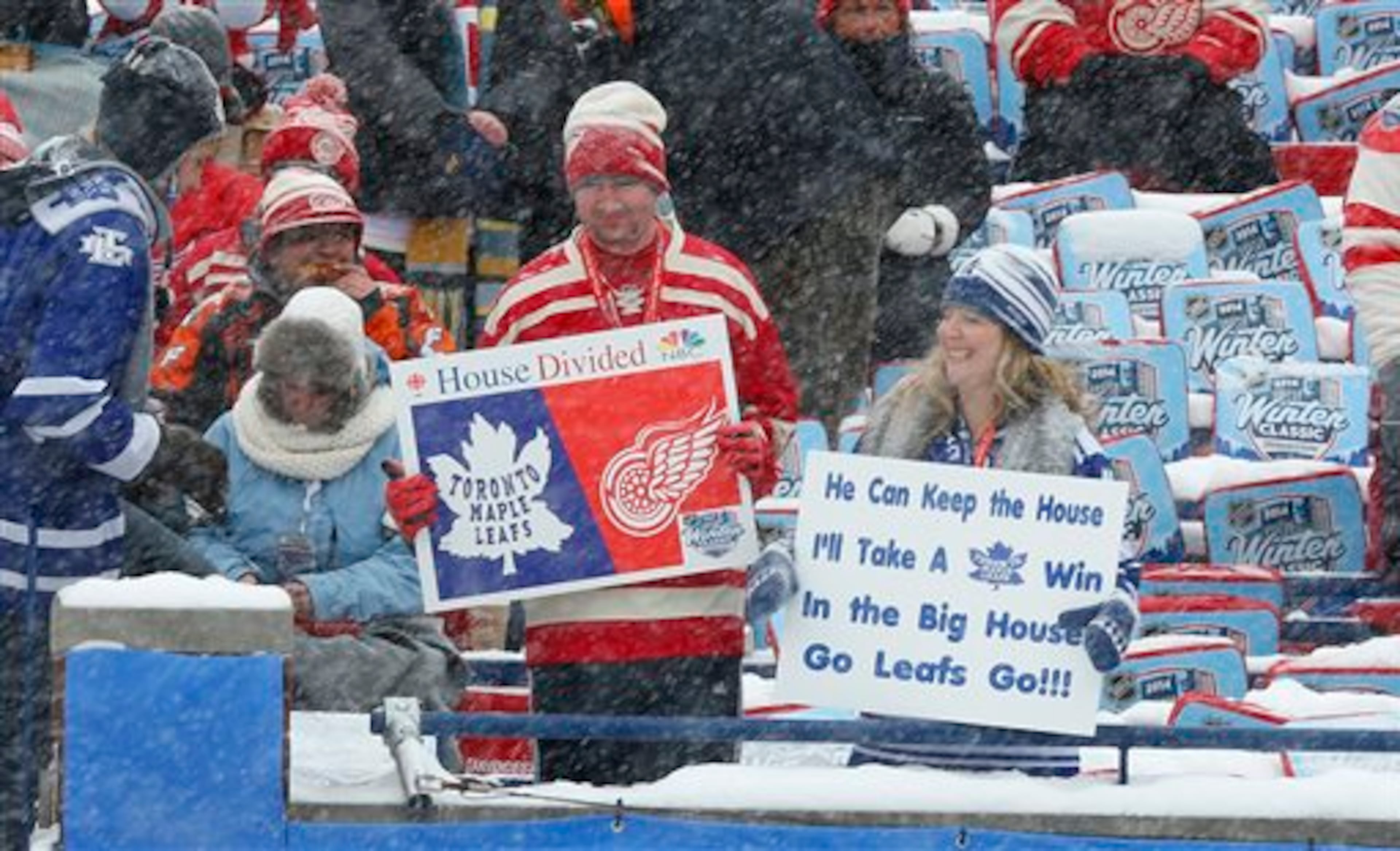 Hockey fans hold up signs during the first period of the Winter Classic outdoor NHL hockey game between the Detroit Red Wings and the Toronto Maple Leafs at Michigan Stadium in Ann Arbor, Mich., Wednesday, Jan. 1, 2014. (AP Photo/Paul Sancya)