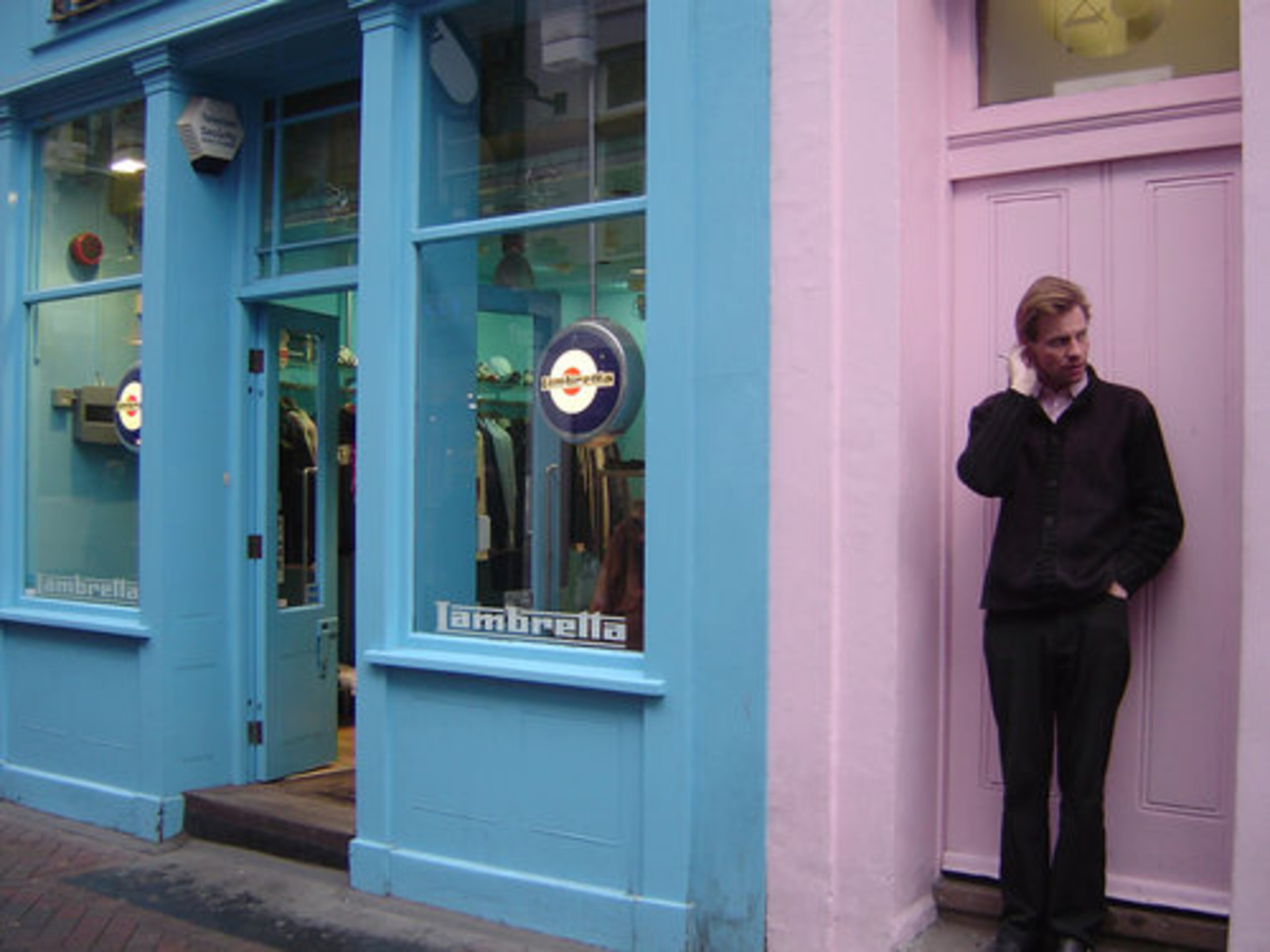 A hipster takes a smoke break next to the Lambretta store, where scooter culture rules.