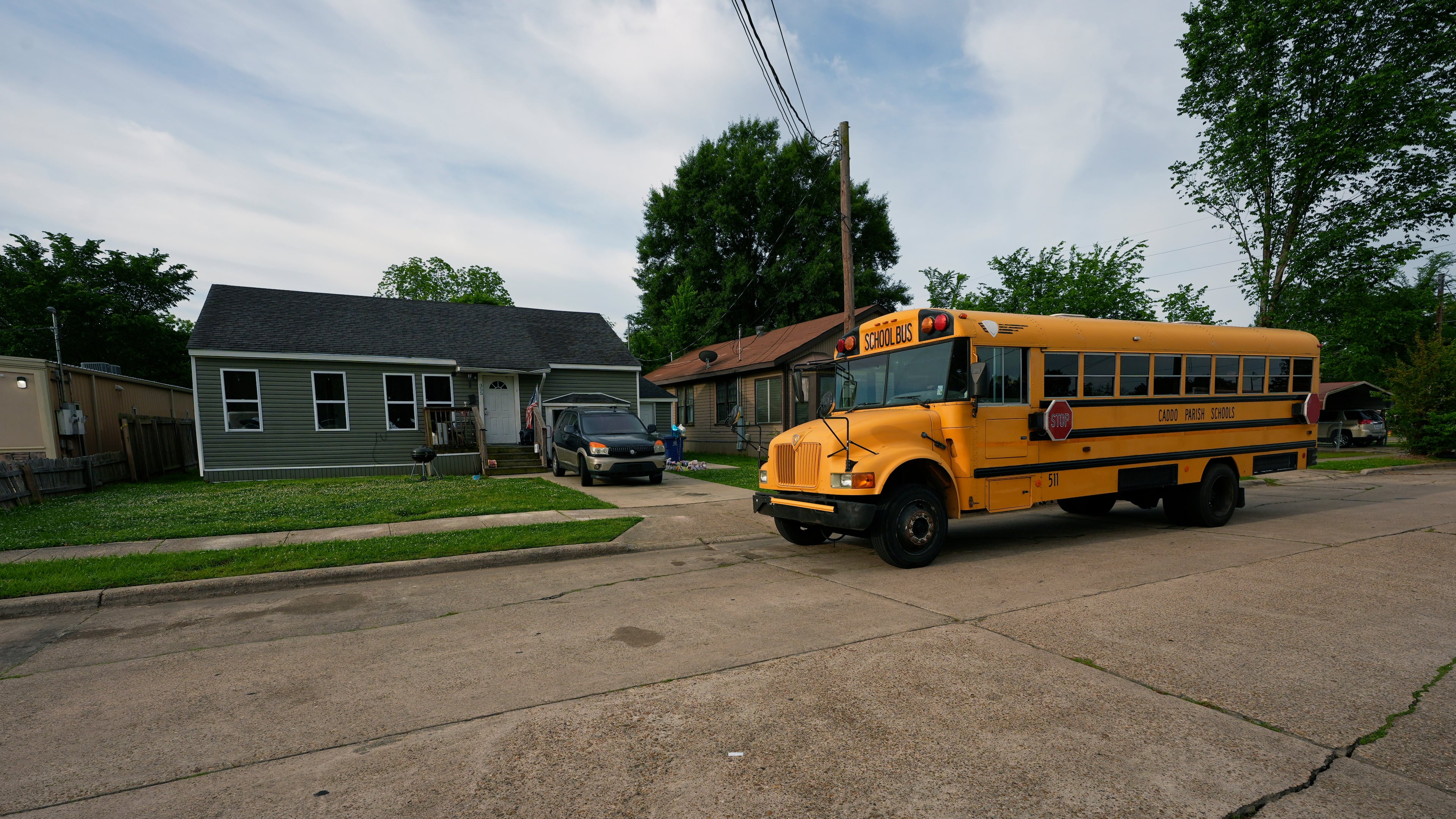A school bus passes the house where 8 children were killed during a mass shooting the day before in Shreveport, La., Monday, April 20, 2026. (AP Photo/Gerald Herbert)