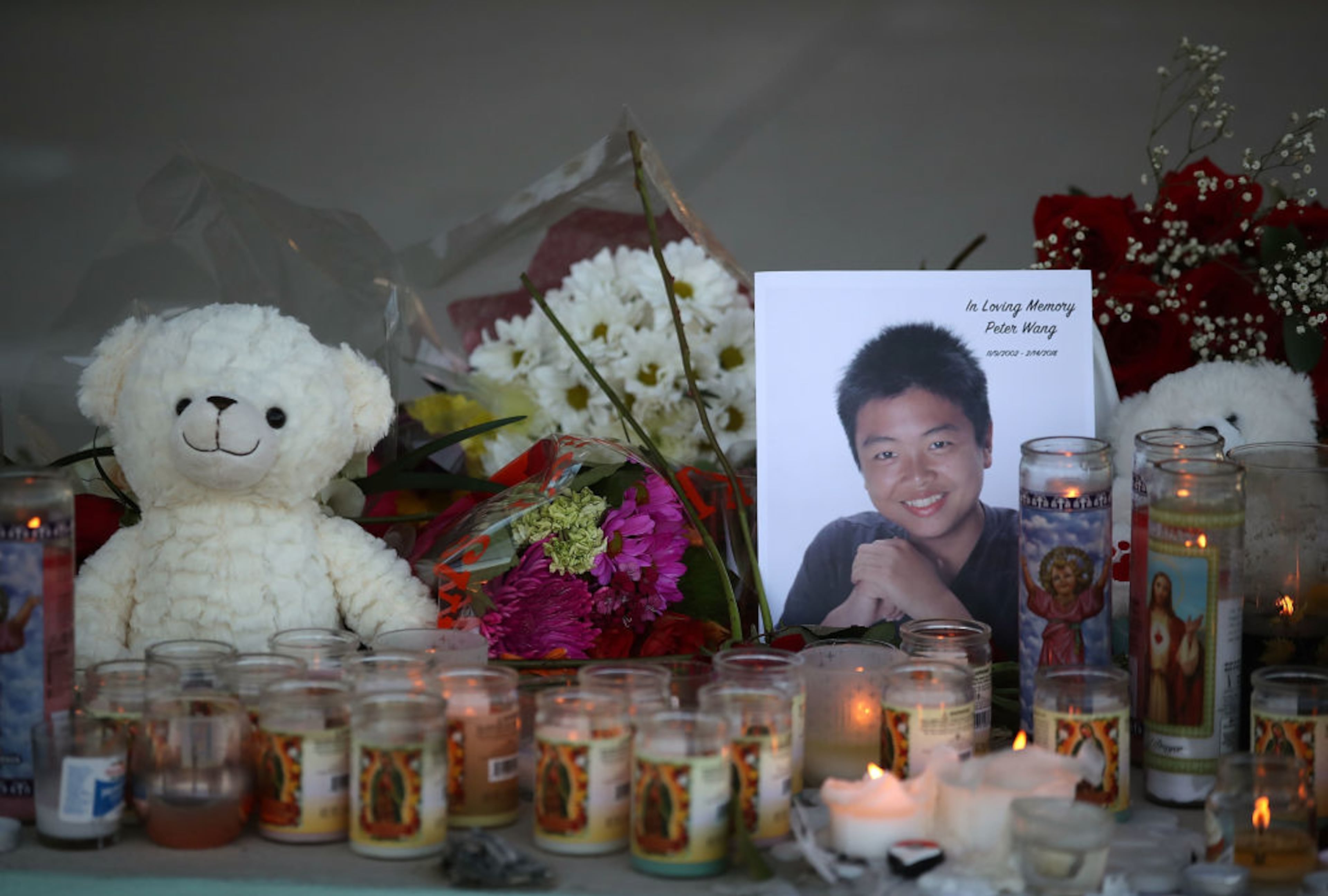Candles glow in front of an undated image of Peter Wang, 15, after a vigil on Thursday, Feb. 15, 2018, for victims of the mass shooting at Marjory Stoneman Douglas High School in Parkland, Florida. Peter was killed when police said former student Nikolas Cruz opened fire on students and staff on Wednesday, Feb. 14, 2018. (Photo by Mark Wilson/Getty Images)