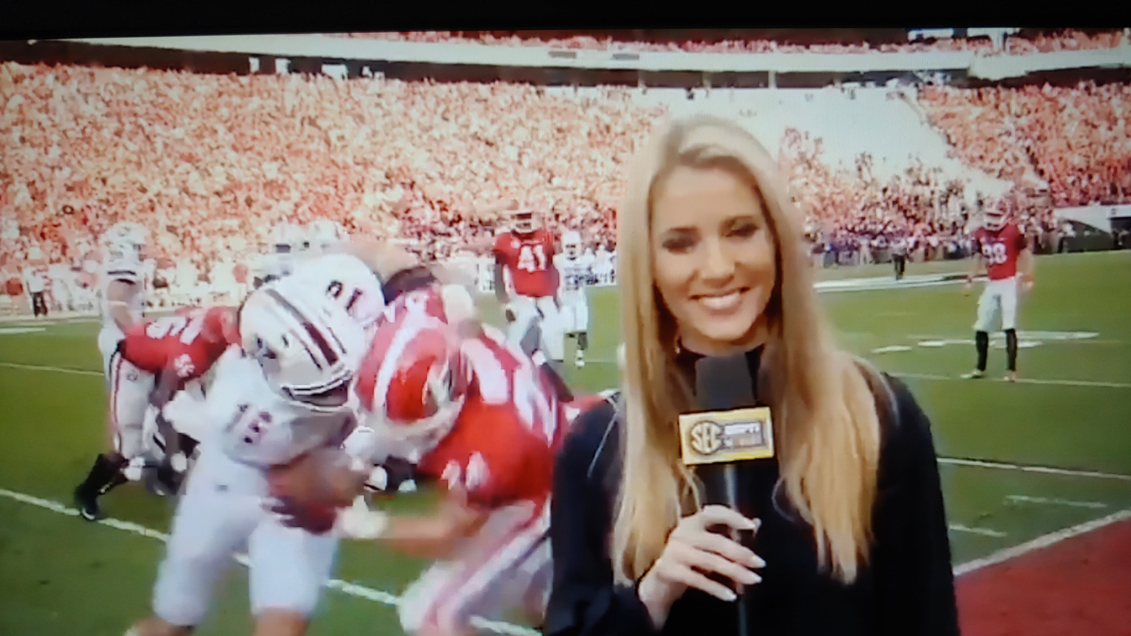 UGA football player Prather Hudson (entangled with UMass player Josiah Johnson) prepares to bump into Laura Rutledge of the SEC Network during last Saturday's game in Athens. (Screenshot via Laura M Rutledge twitter)