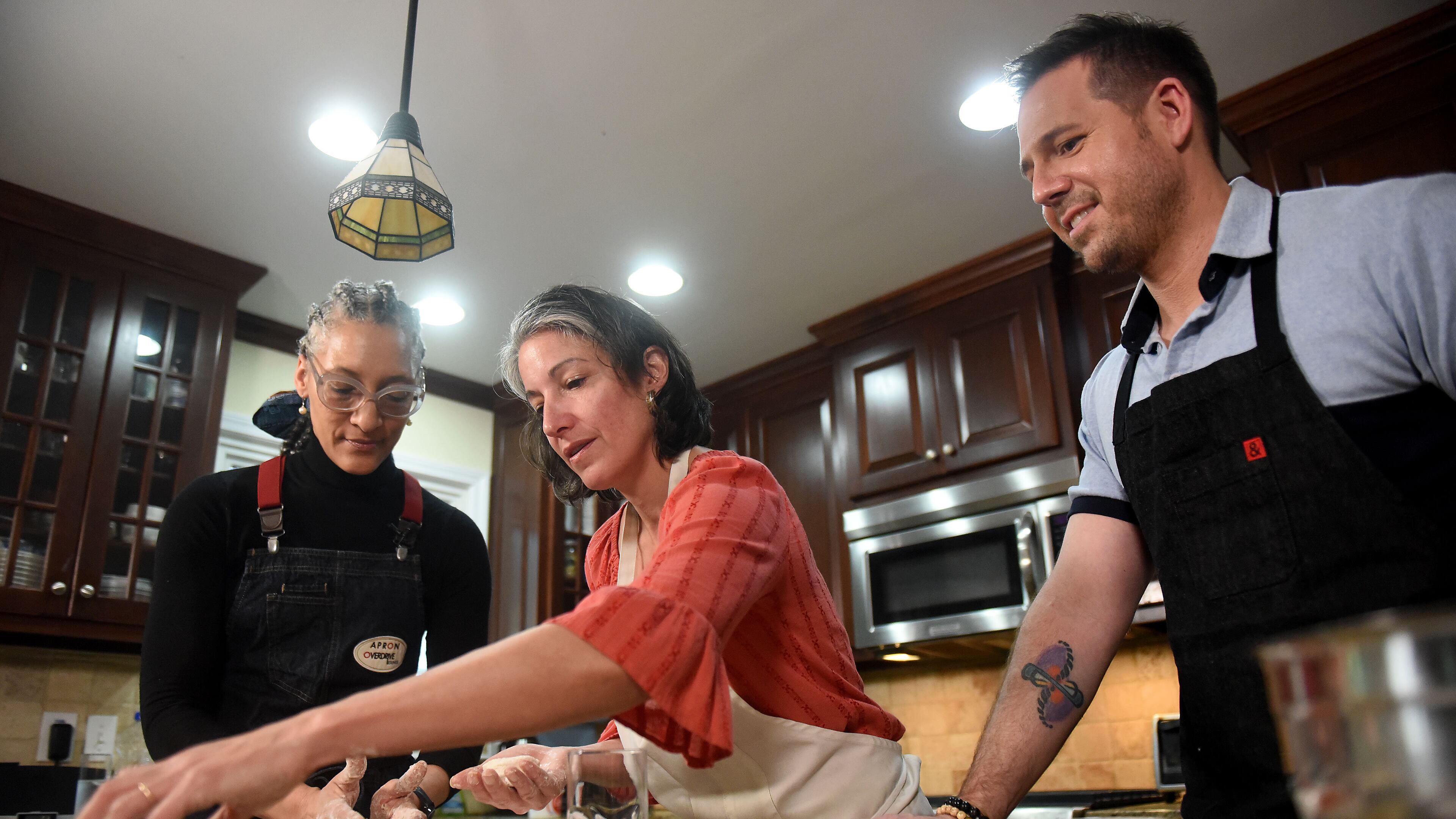 The AJC's Ligaya Figueras (center) hosts food expert Chadwick Boyd (right) and Top Chef Carla Hall (left) at her home, where the two share tips with Ligaya on how to make the best biscuits. RYON HORNE / RHORNE@AJC.COM