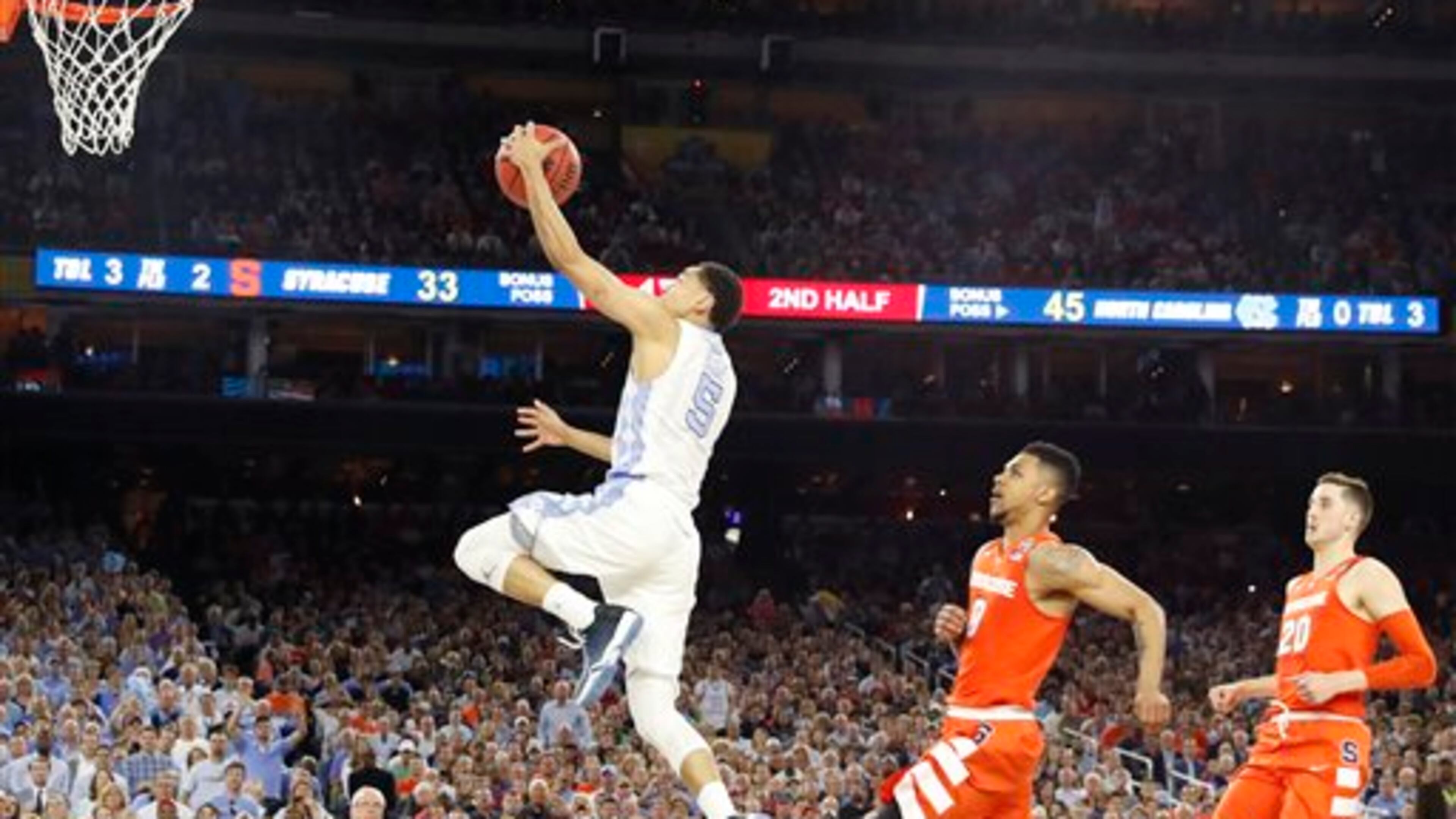 North Carolina guard Marcus Paige (5) leaps toward the goal as Syracuse forward Michael Gbinije (0) gives chase during the second half of the NCAA Final Four tournament college basketball semifinal game Saturday, April 2, 2016, in Houston. (AP Photo/David J. Phillip)