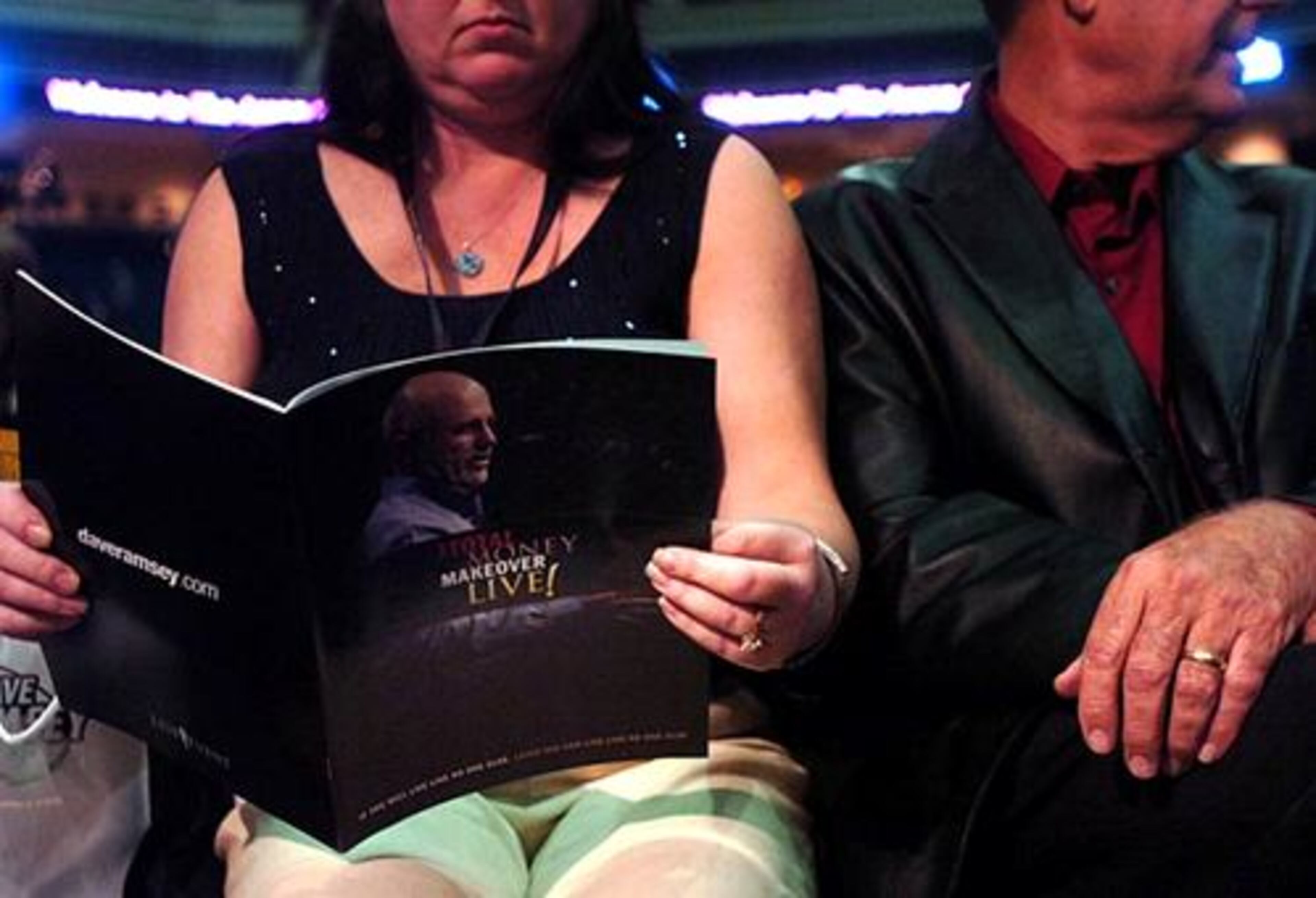 Wendy Anderson reads some literature she received at radio host Dave Ramsey's show at the Gwinnett Arena.