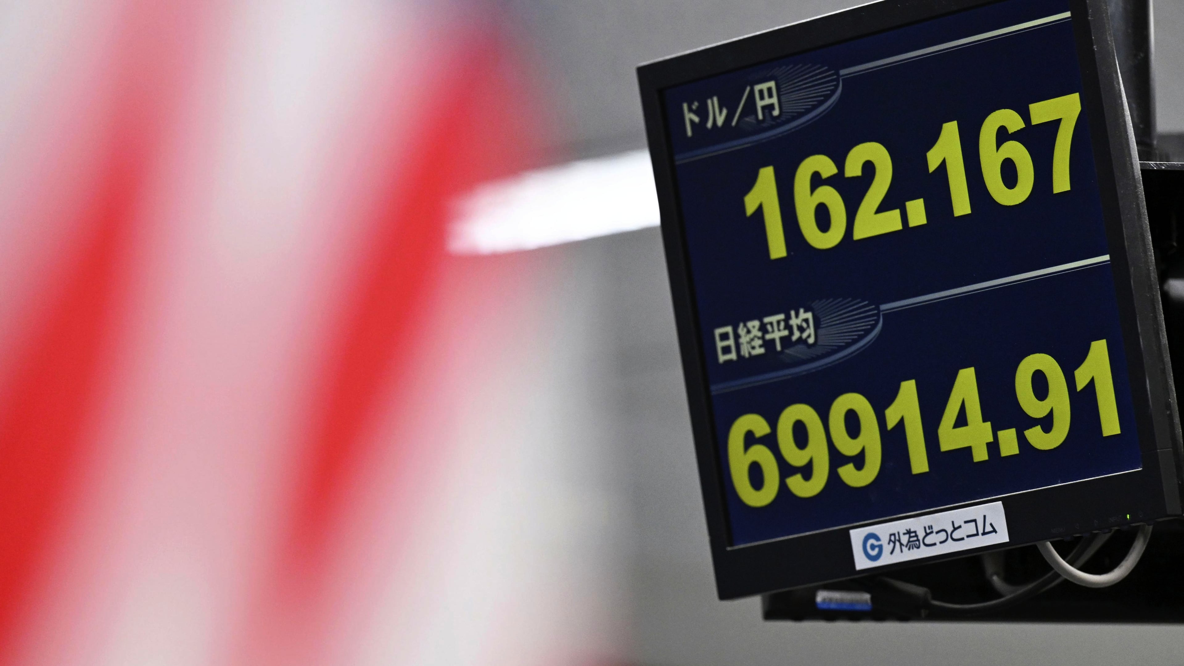 An electronic board shows Japan's benchmark Nikkei 225 index, bottom, and exchange rate of the Japanese yen against the U.S. dollar in Tokyo Tuesday, June 30, 2026. (Kenichiro Kojima/Kyodo News via AP)