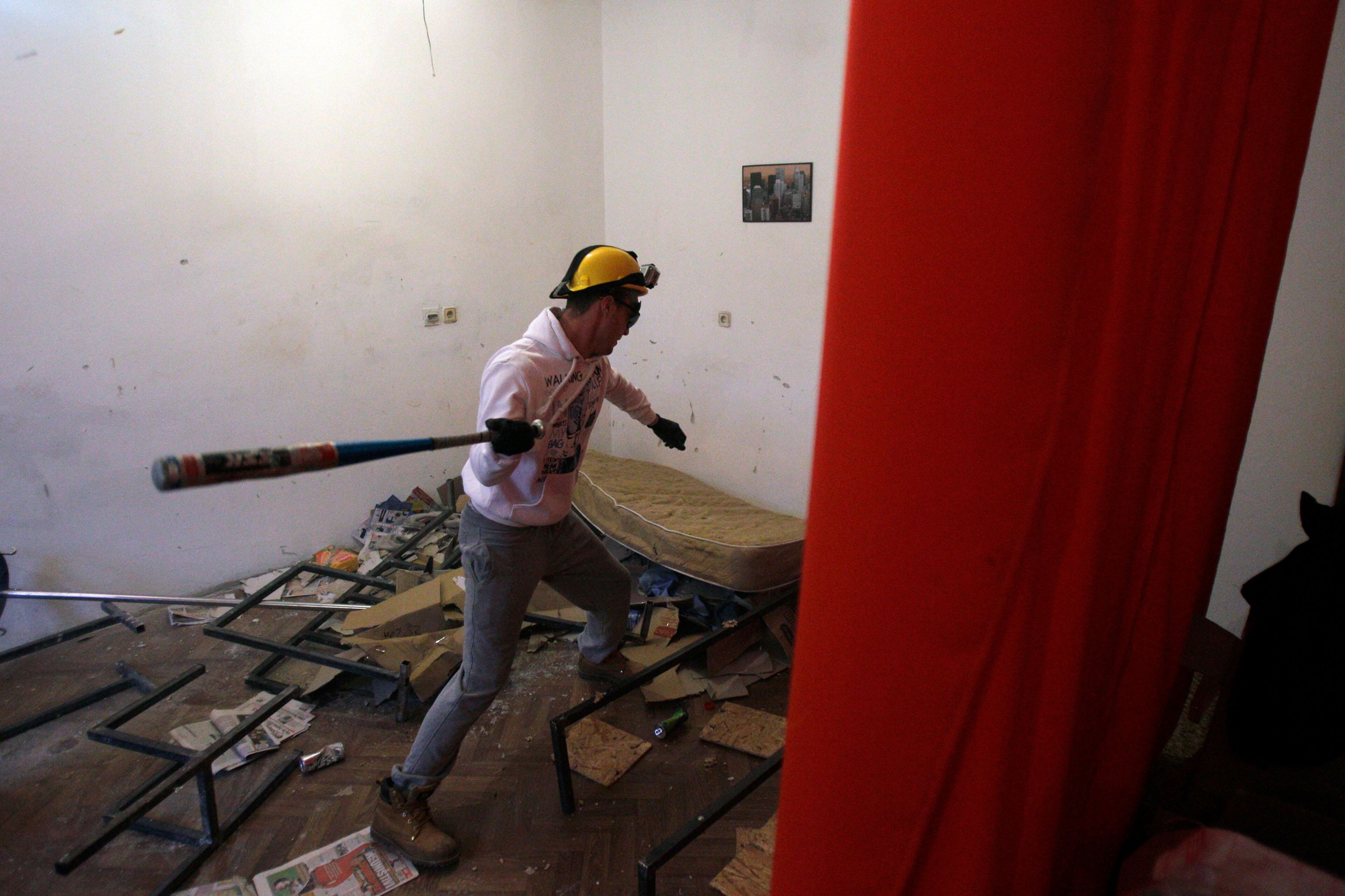 In this Dec. 27, 2012 photo visitor Savo Duvnjak smashes furniture and other household items during a demolishing session at the Rage Room, in Novi Sad, Serbia.