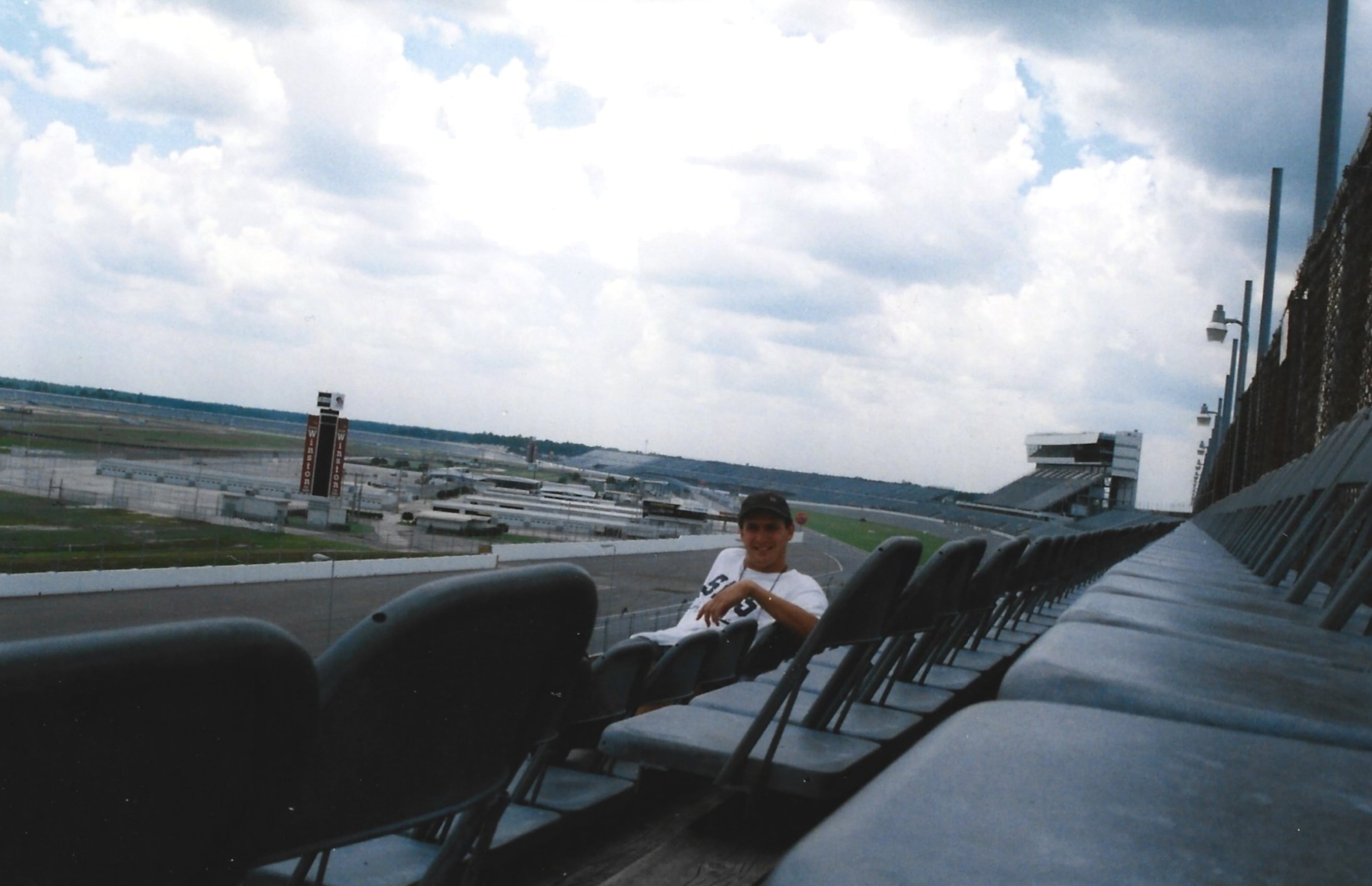 Steve sits at Daytona Motor Speedway, which hosts the infamous Daytona 500. He said he wanted to visit Daytona because he played a Daytona 500 arcade game growing up in Australia. (Courtesy of Steve Leo)