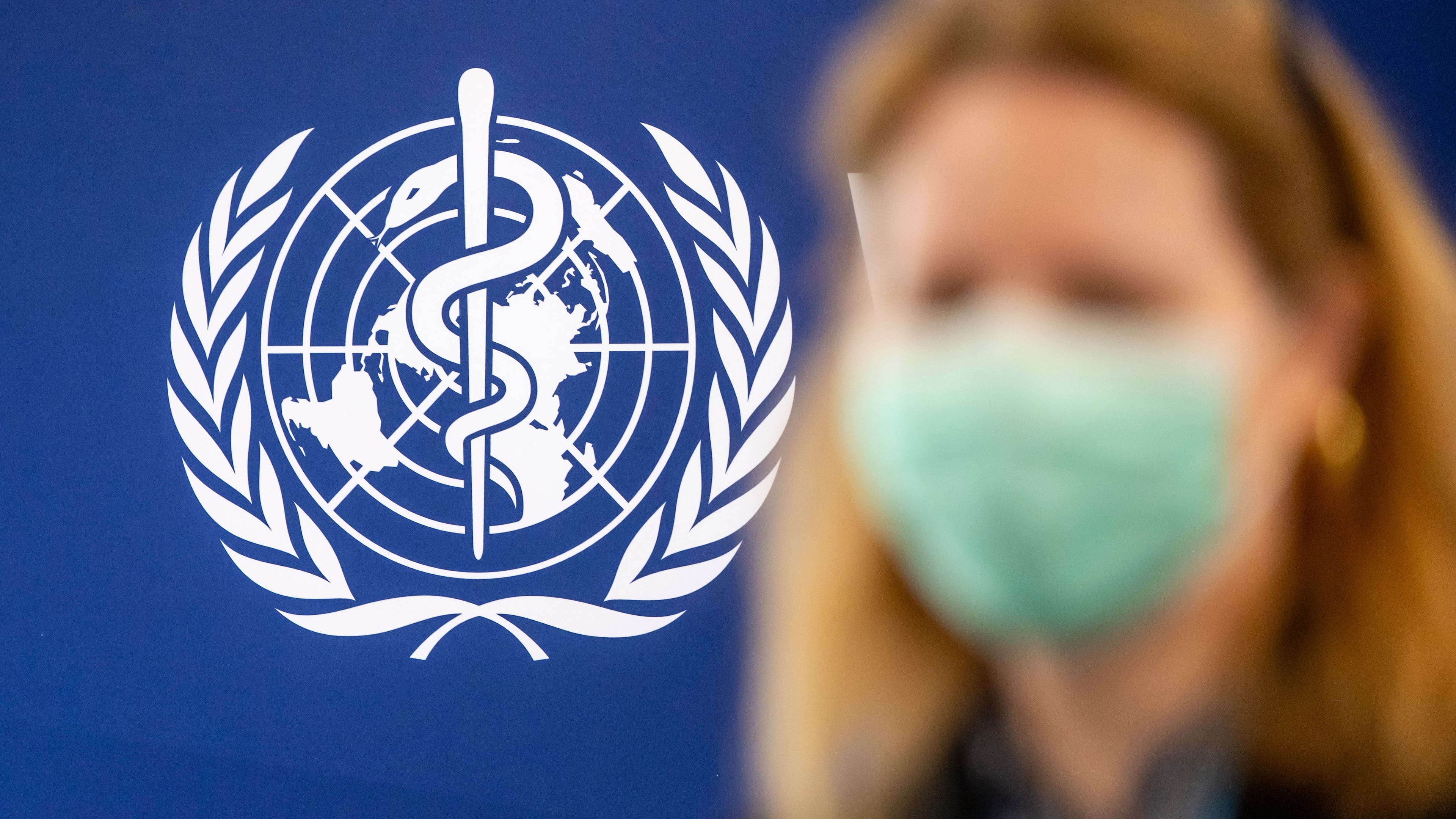 A person is wearing a protective face mask in front of the WHO logo, during the media regarding the epidemic of Ebola disease, during a press conference at the World Health Organization (WHO) headquarters in Geneva, Switzerland, Friday, May 22, 2026. (Martial Trezzini/Keystone via AP)