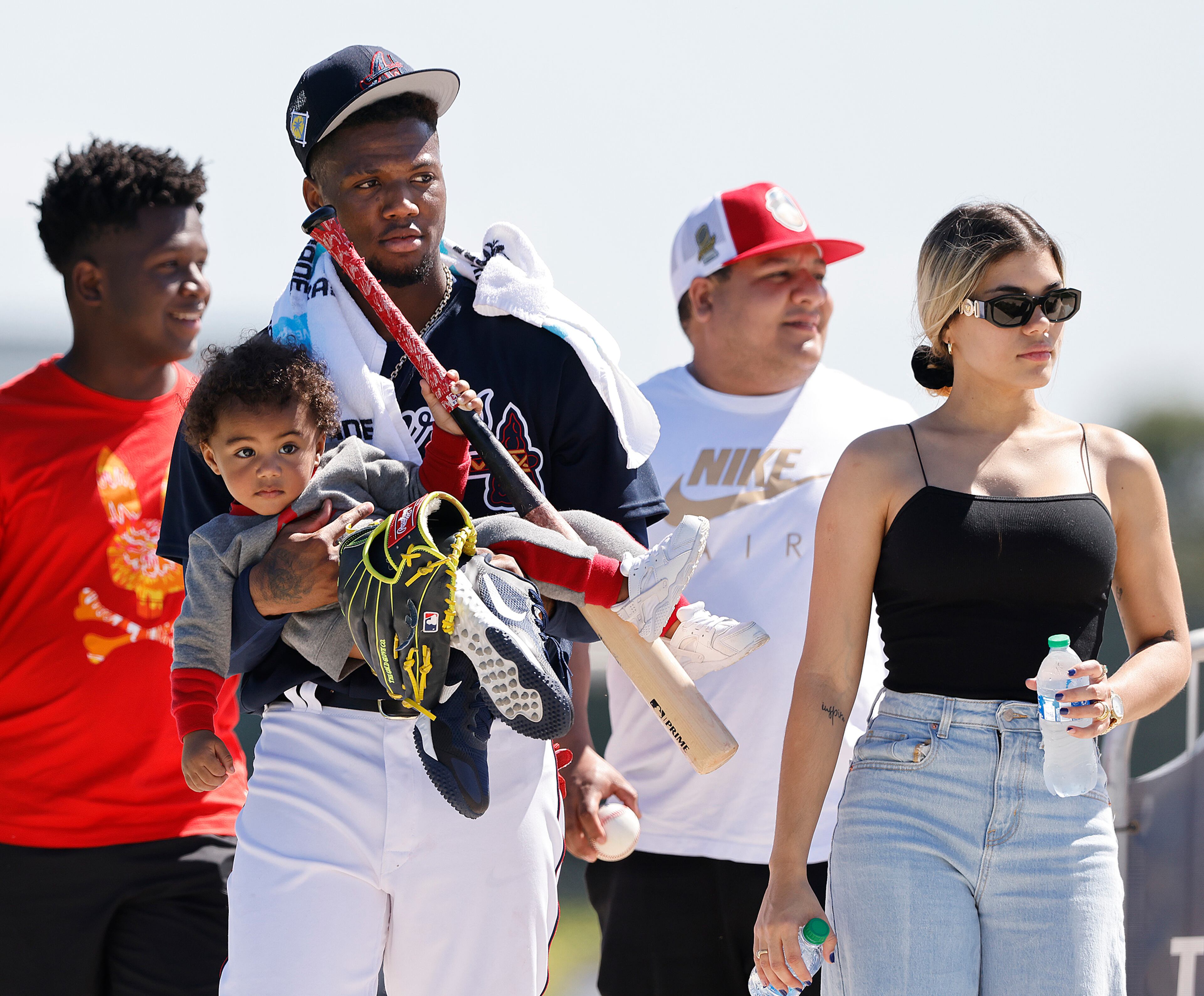 Braves outfielder Ronald Acuna carries his son Ronald Acuna Jr. II after he finishes up practice for the day and leaves with his partner Maria Laborde (right) during Spring Training on Thursday, March 17, 2022, in North Port. “Curtis Compton / Curtis.Compton@ajc.com”
