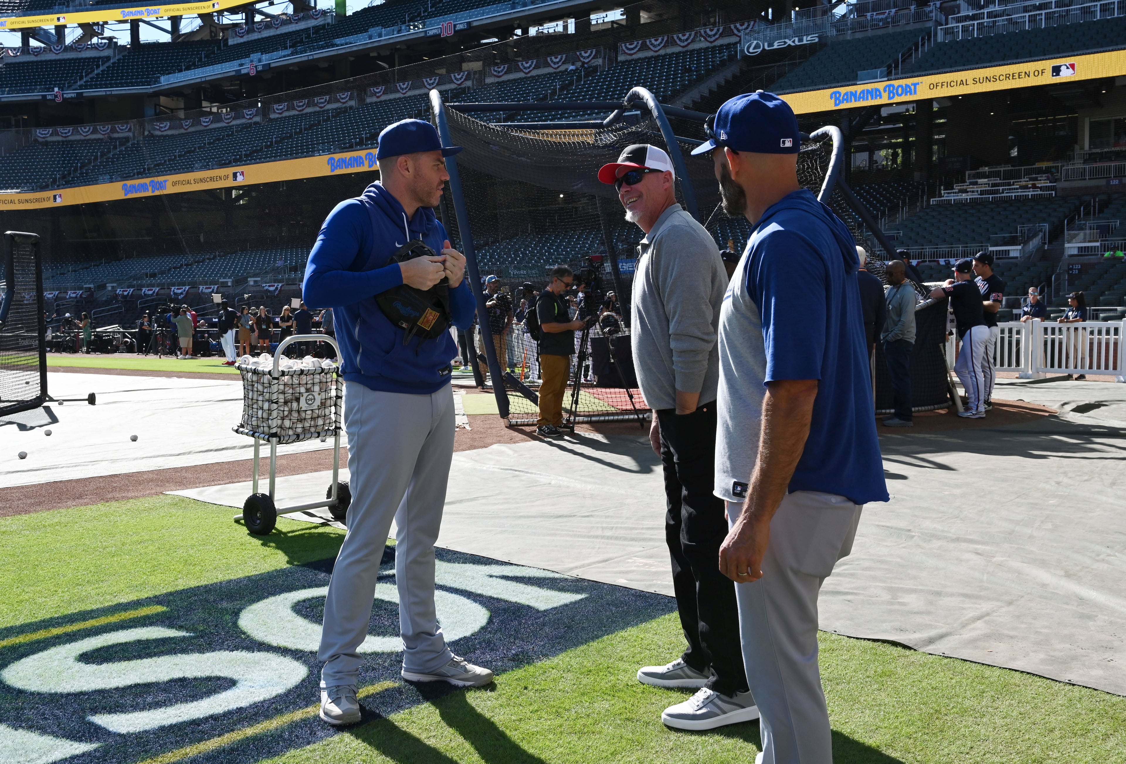 Former Braves star Chipper Jones, center, talks with Los Angeles Dodgers first baseman Freddie Freeman, left, before Game 3 of the National League Division Series at Truist Park on Tuesday, Oct. 6, 2026, in Atlanta. (Hyosub Shin/AJC)