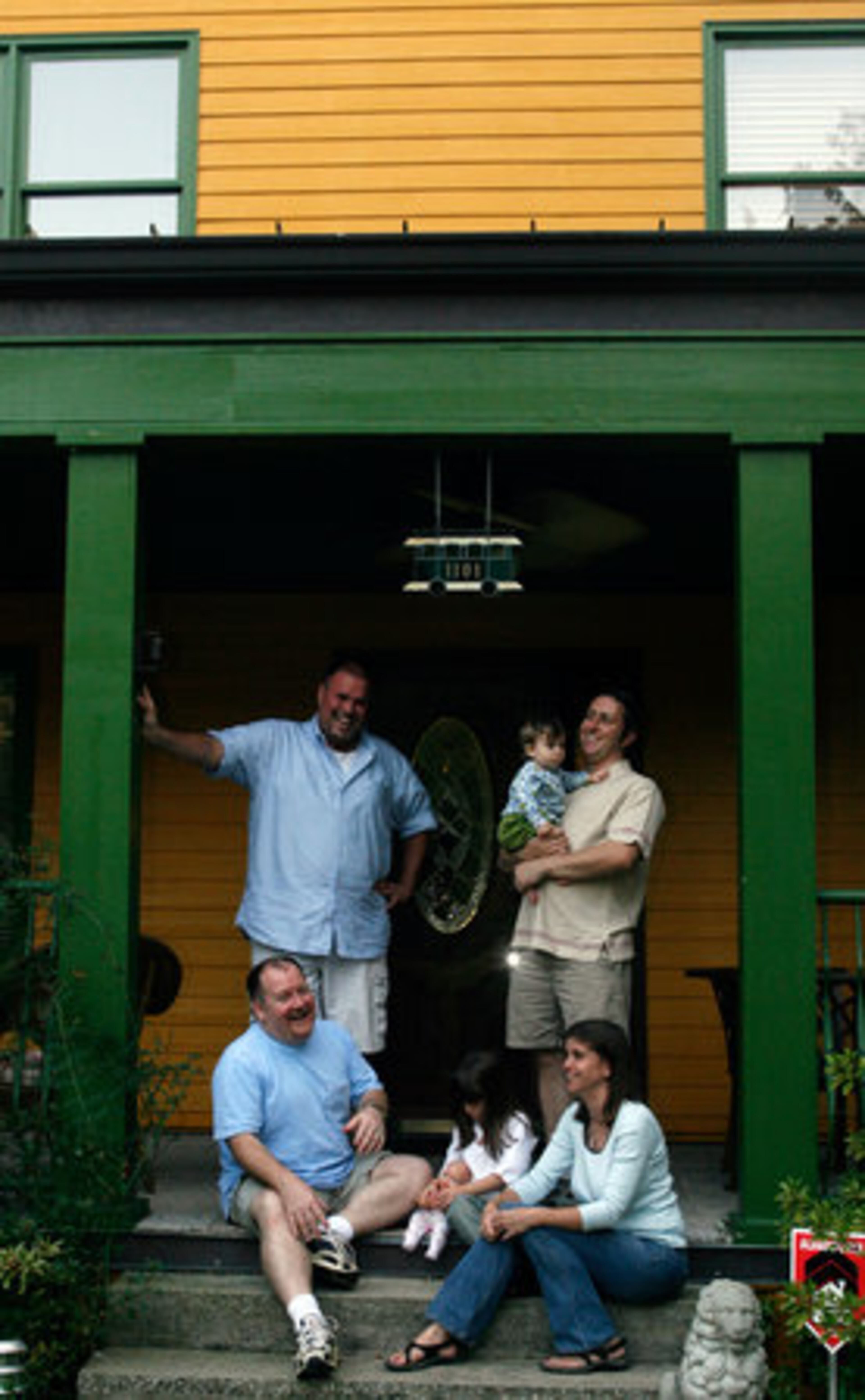 From bottom left: Peter Bolognese and his partner Francois McCord, Matt Sanders, son Everett, 8 months, Shannon Sanders and daughter Willow, 4, sit on the steps of Bolognese and McCord's Ormewood Park home. Both families say residents appreciate and celebrate the diversity of their south Atlanta neighborhood.