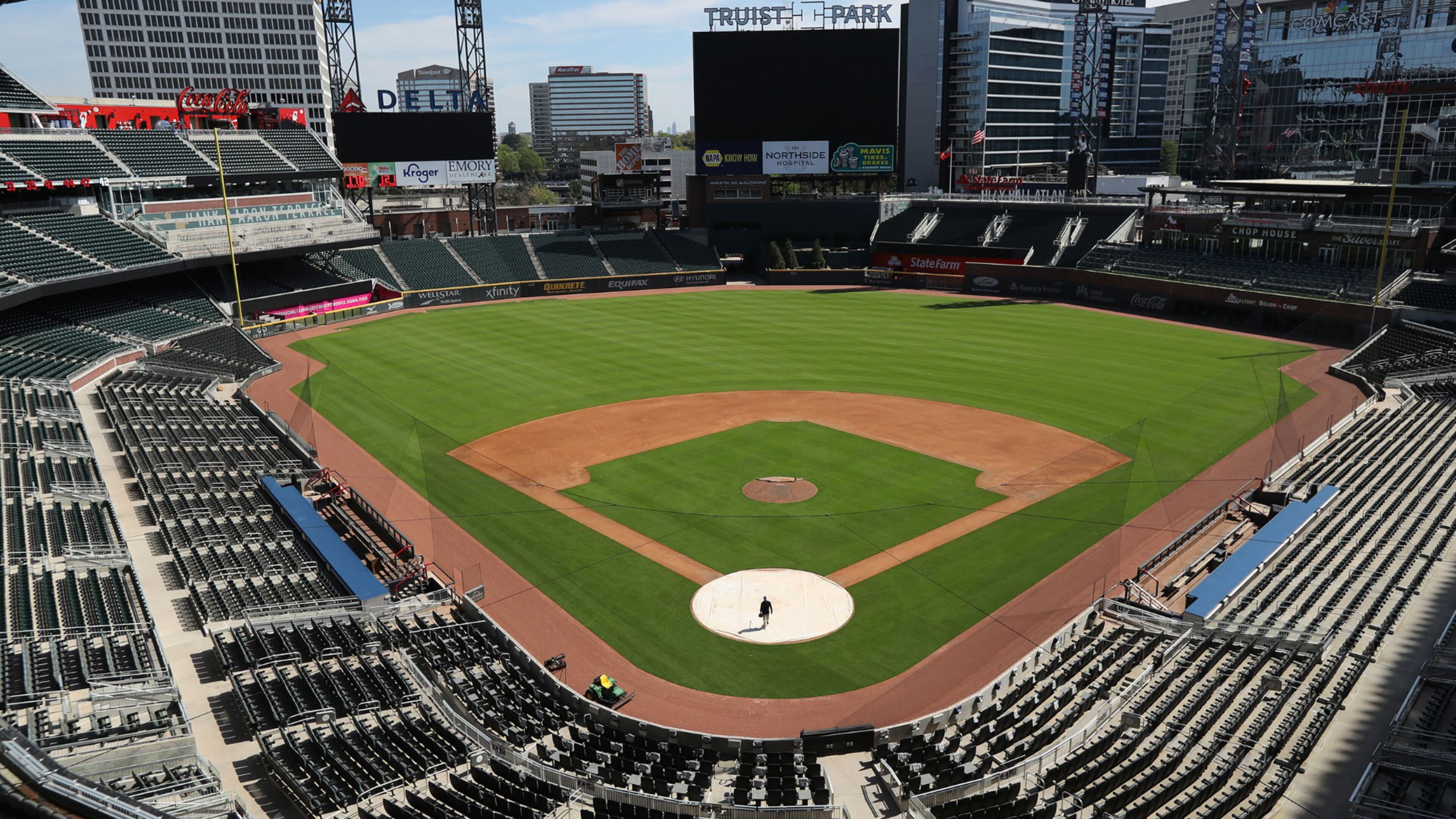 April 1, 2020 Atlanta: The stadium is eerily quiet except for Atlanta Braves field manager Tyler Lenz walking across the covered home plate while maintaining the quality of the field in the team���s newly renamed Truist Park on Wednesday, April 1, 2020, in Atlanta. The Braves were suppose to host their home opener this Friday, but the season���s start was postponed by Major League Baseball because of the coronavirus pandemic. A basic crew is keeping the quality of the field up to playing conditions while no one knows when, or even if, the 2020 season will start, or how long it might last. Curtis Compton ccompton@ajc.com