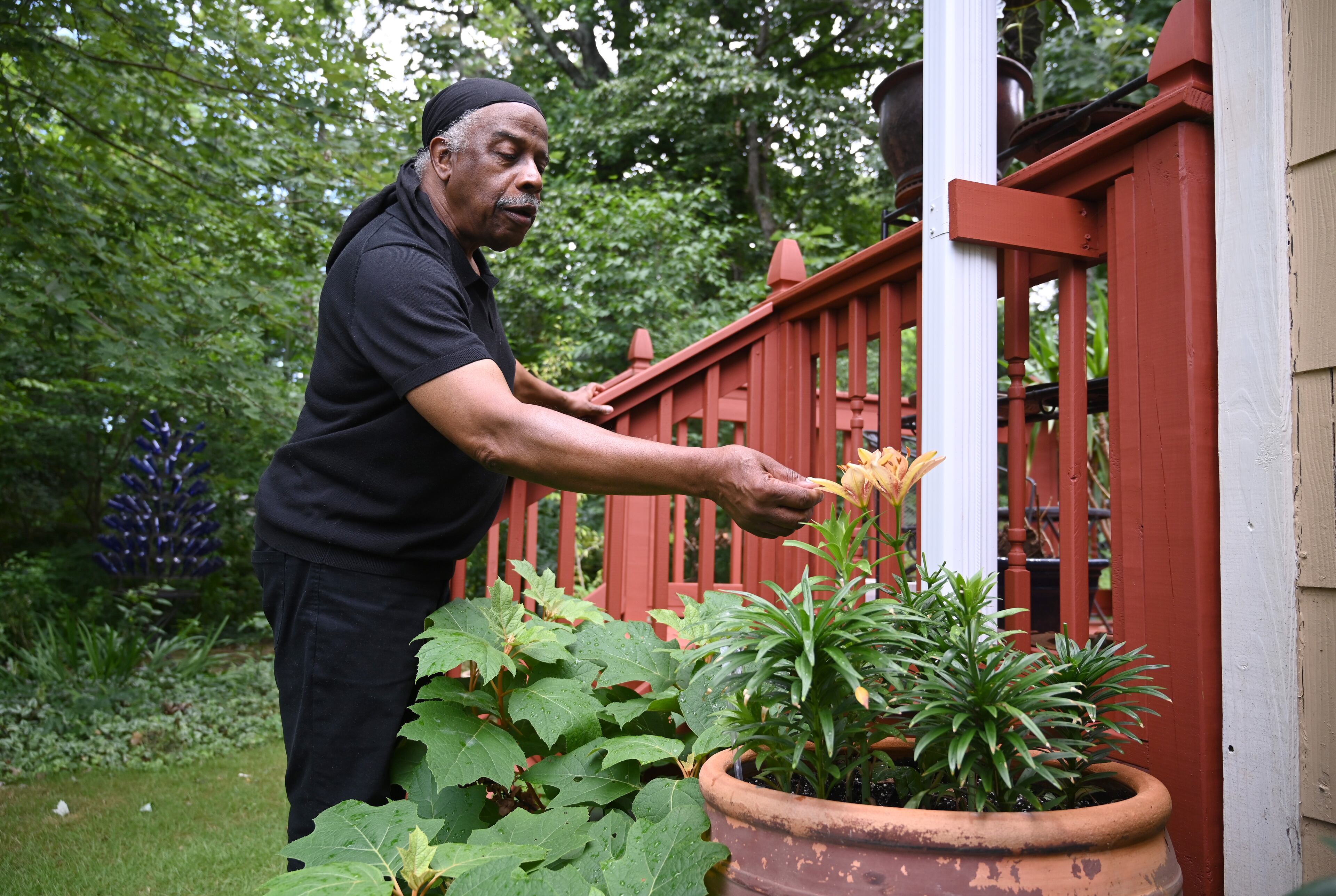 Styles expresses gratitude to artist Carl Christian for providing a place to stay by tending to the plants in his garden. (Hyosub Shin/AJC)