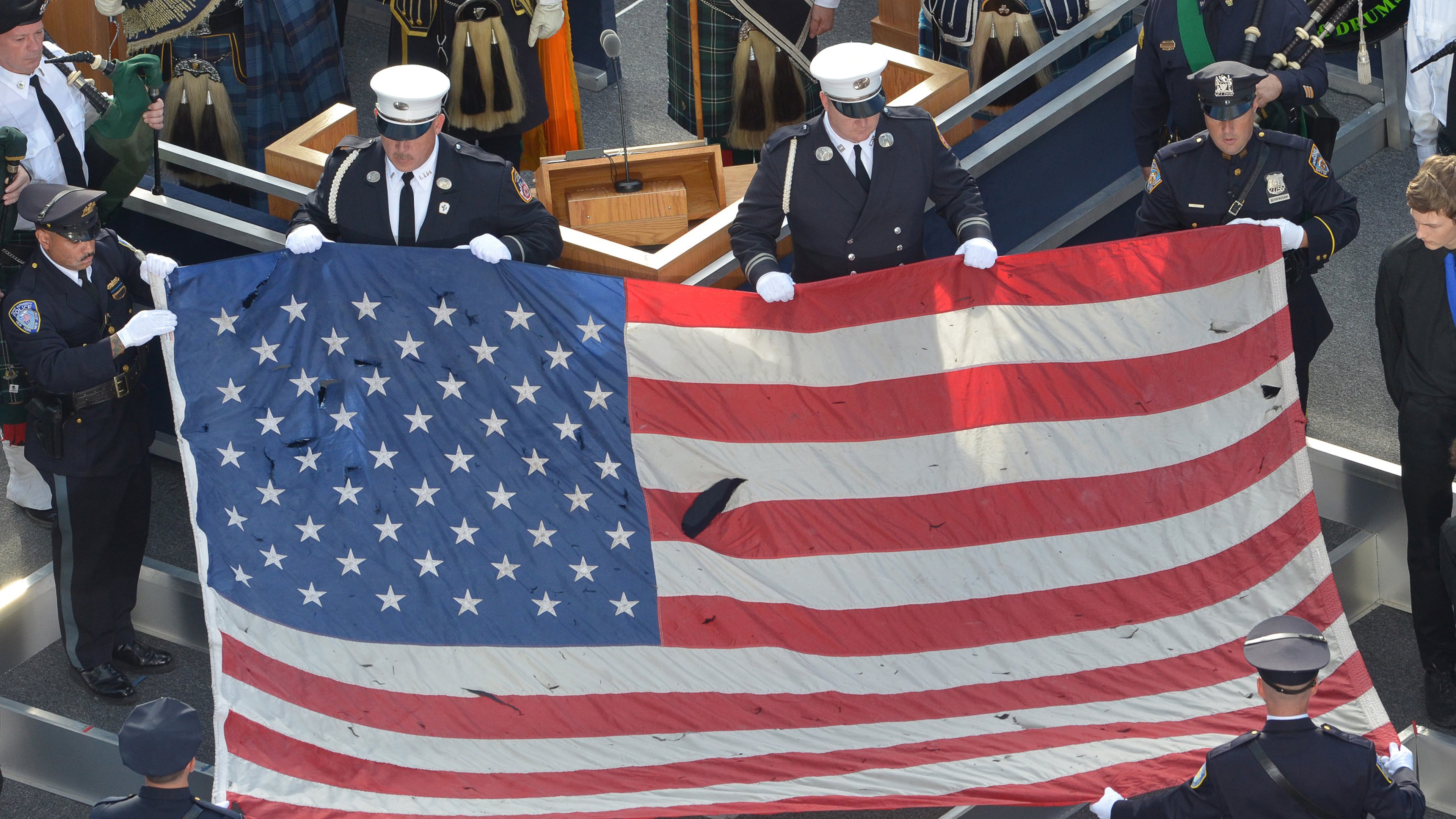 Pictured is a U.S. flag recovered from the 9/11 attacks is displayed by New York City Police officers and firefighters during the ceremony marking the 10th anniversary of the terrorist attack in 2011. In the September 11, 2001 attacks, Al-Qaeda hijackers crashed passenger planes into the World Trade Center in New York and the Pentagon in Washington, while a fourth jet crashed in Shanksville, Pennsylvania. (Mladen Antonov/AFP/Getty Images/TNS)