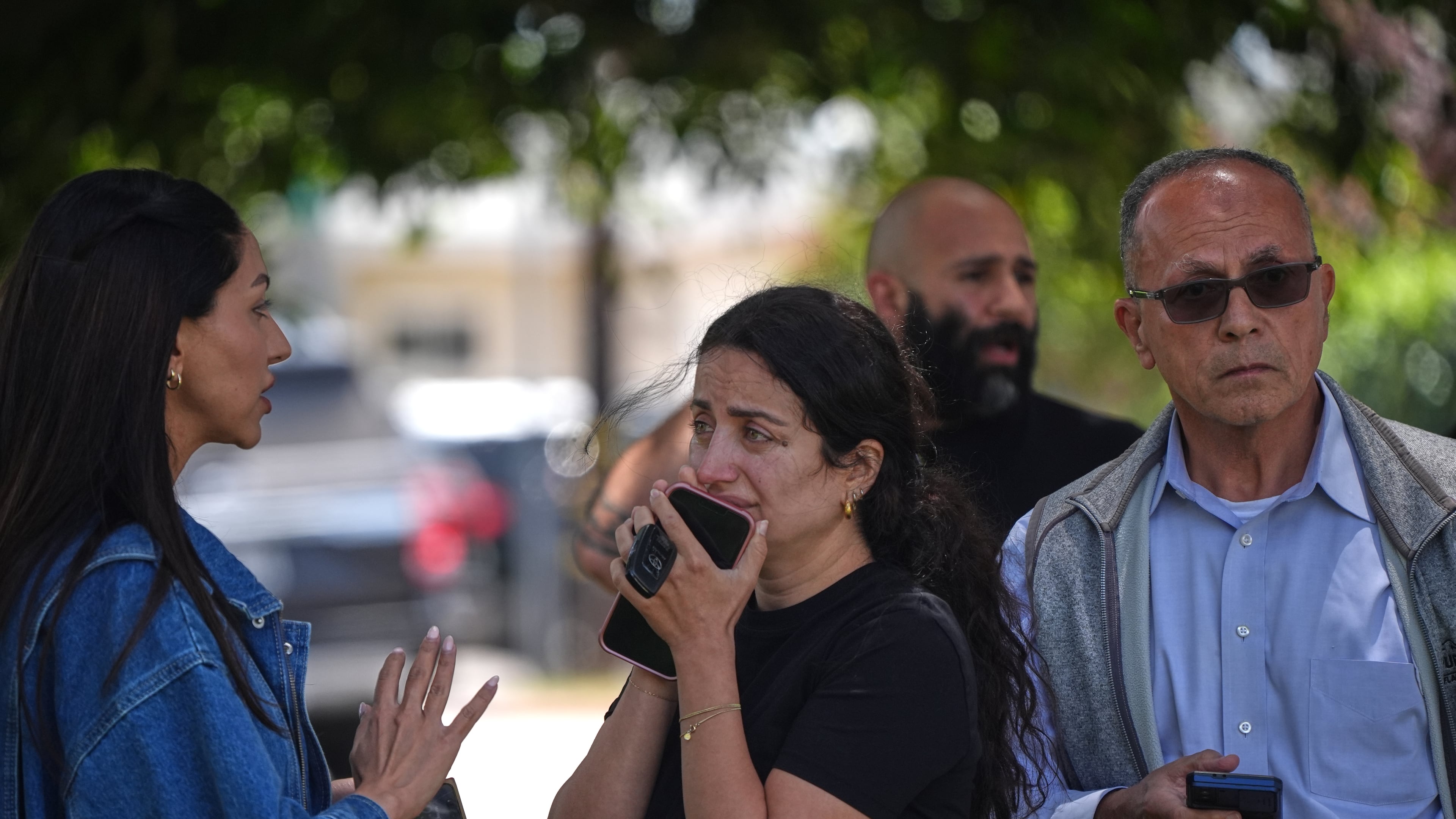 People stand behind police tape at the scene of a shooting outside the Islamic Center of San Diego Monday, May 18, 2026, in San Diego. (AP Photo/Gregory Bull)