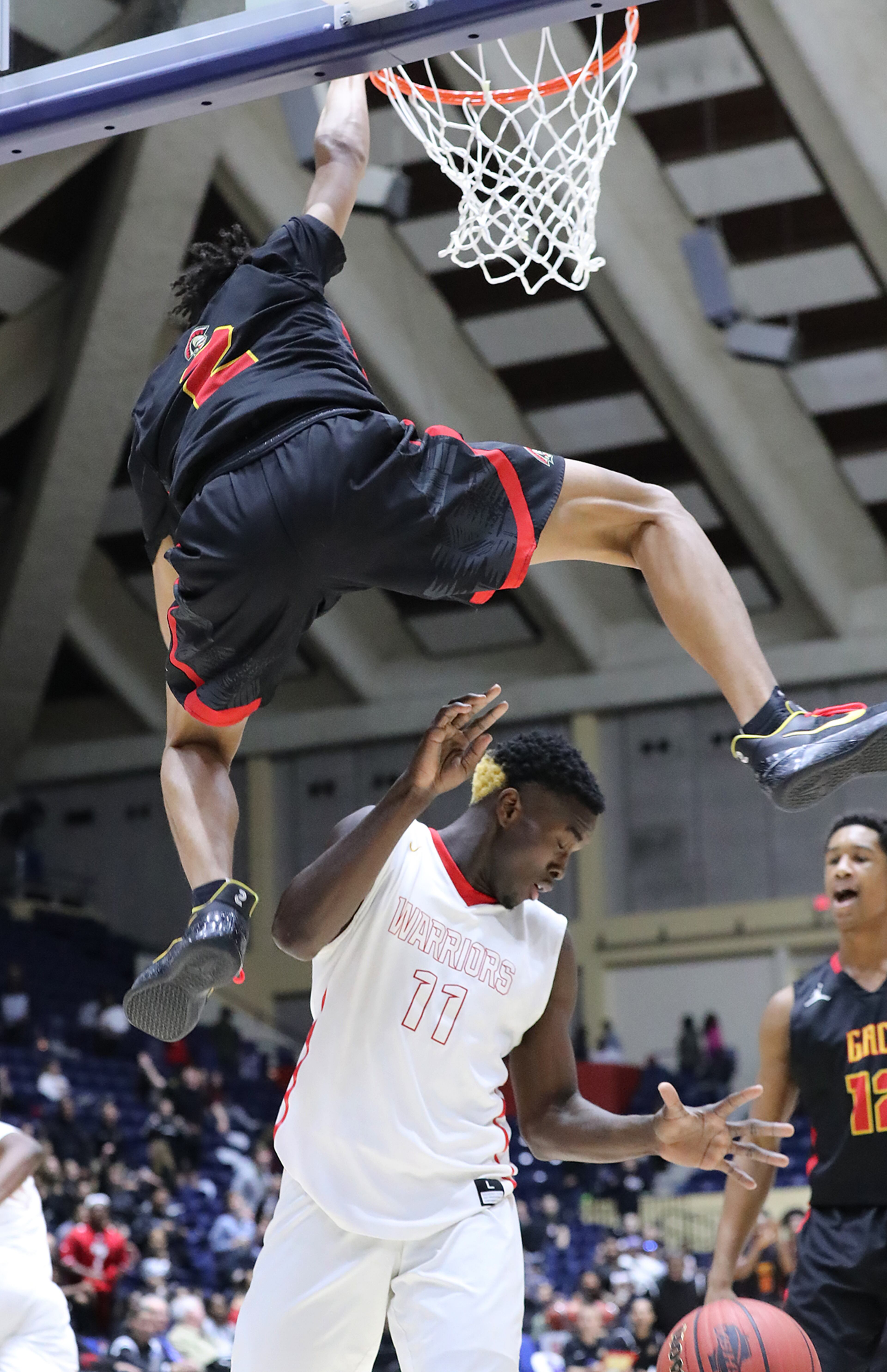 March 8, 2018 Macon: GAC guard Ben Sheppard hangs on the basket slamming for two over Jenkins wing Tyrone Scott in their GHSA state basketball championship game on Thursday, March 8, 2018, in Macon. Curtis Compton/ccompton@ajc.com