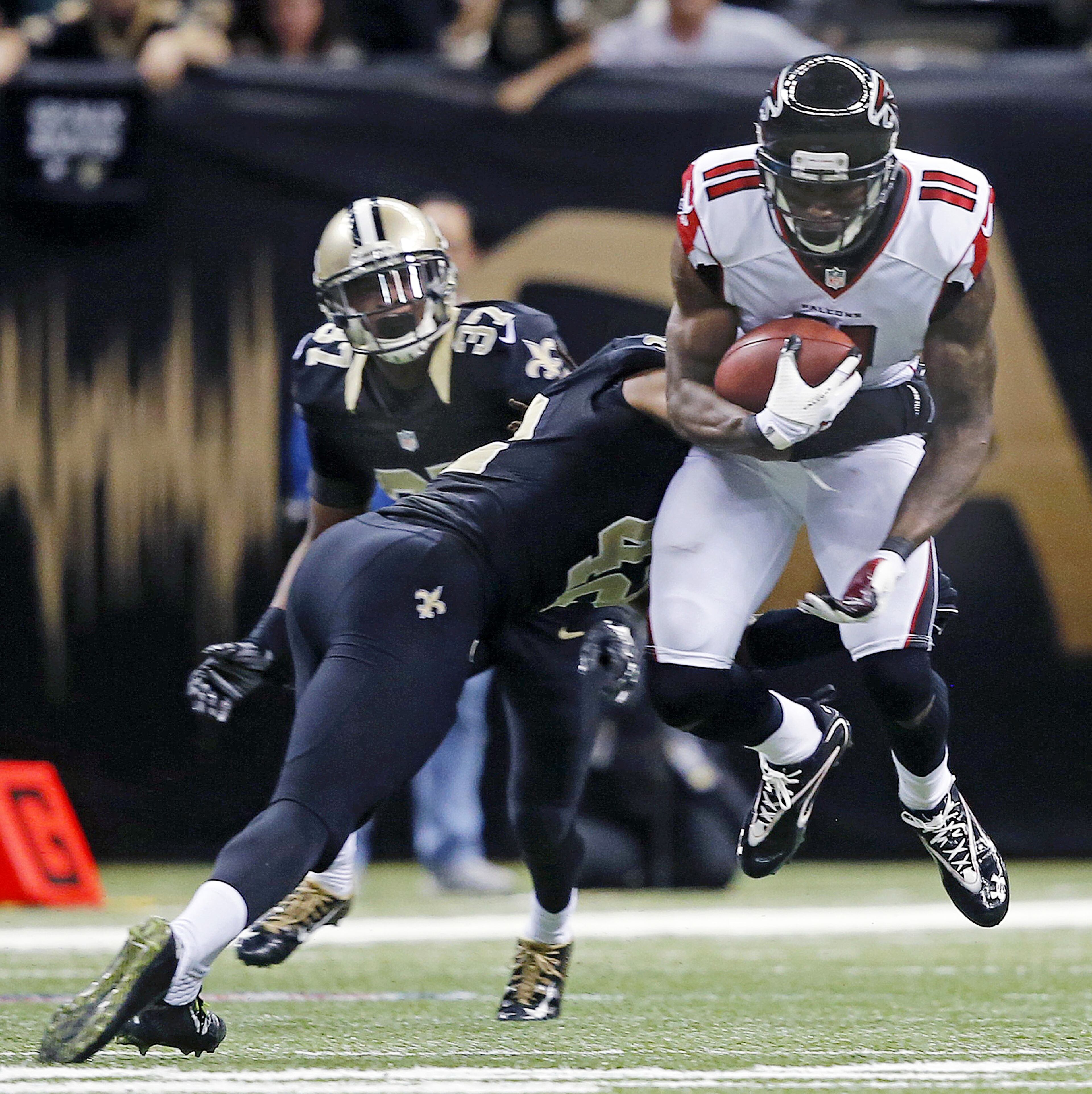 Atlanta Falcons wide receiver Julio Jones (11) is tackled by New Orleans Saints defensive back Pierre Warren (42) in the second half of an NFL football game in New Orleans, Sunday, Dec. 21, 2014. (AP Photo/Bill Haber)