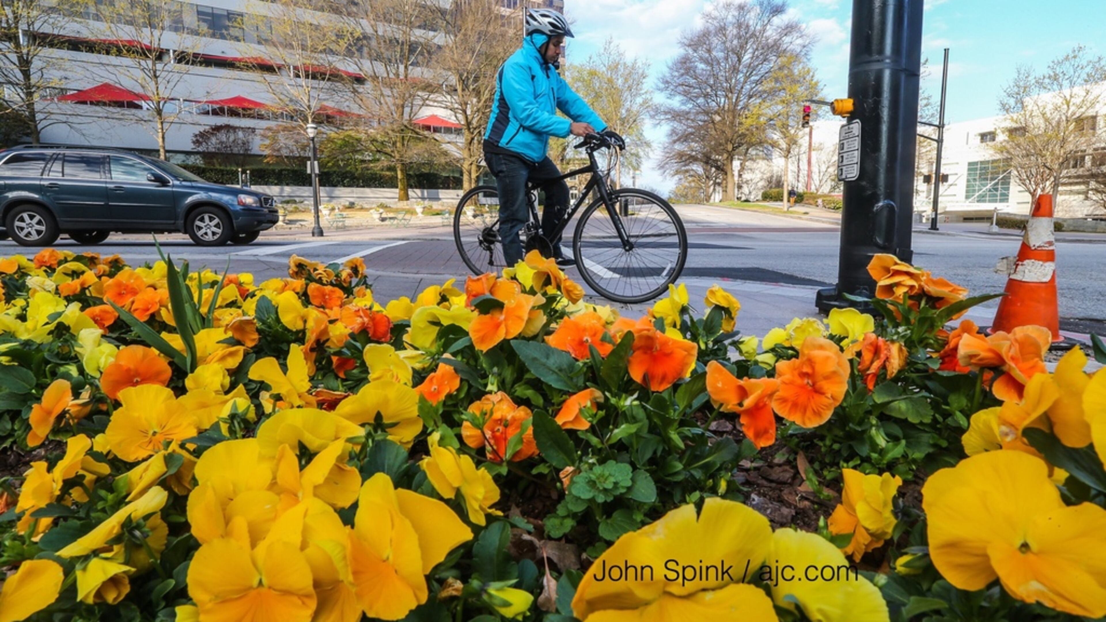 Fernando Vazquez rode his bike at 15th and Peachtree streets on the first day of spring Monday. JOHN SPINK / JSPINK@AJC.COM