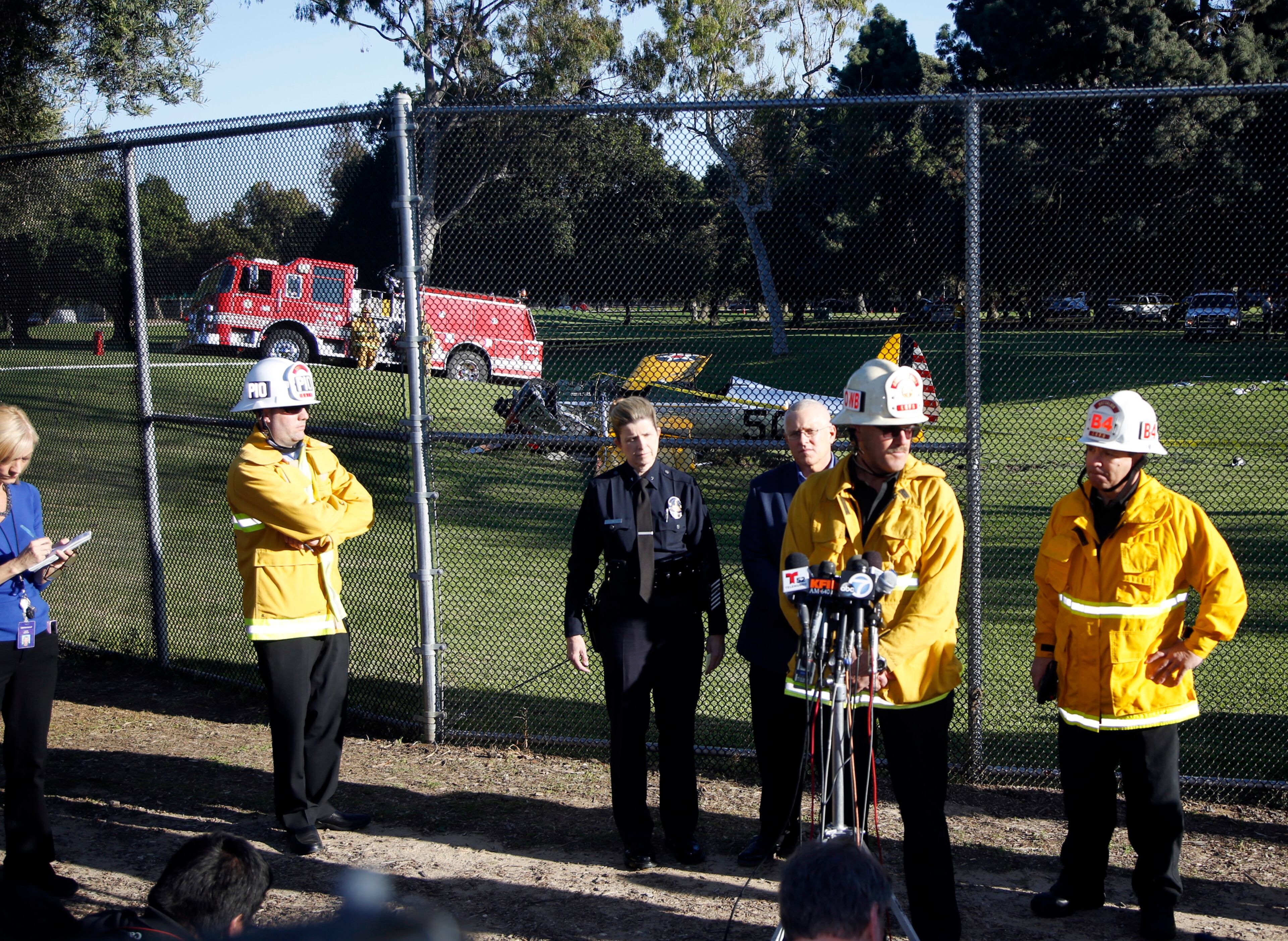 Los Angeles Fire and police officials comment on a small plane that crash-landed on the Penmar Golf Course in the Venice area of Los Angeles, Thursday, March 5, 2015. Harrison Ford crash-landed the airplane shortly after taking off from a nearby airport and reporting engine problems. (AP Photo/Damian Dovarganes)