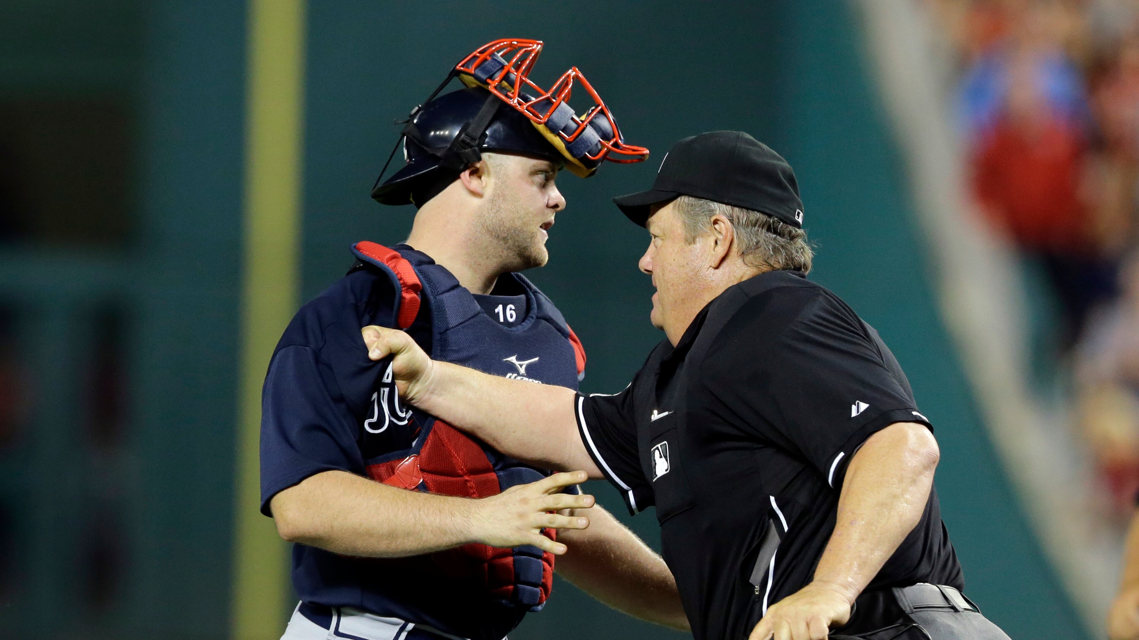 Atlanta Braves catcher Brian McCann (16) is restrained by home plate umpire Joe West (22) after Washington Nationals' Bryce Harper was hit by a pitch during the fifth inning of a baseball game at Nationals Park Tuesday, Aug. 6, 2013, in Washington. (AP Photo/Alex Brandon)