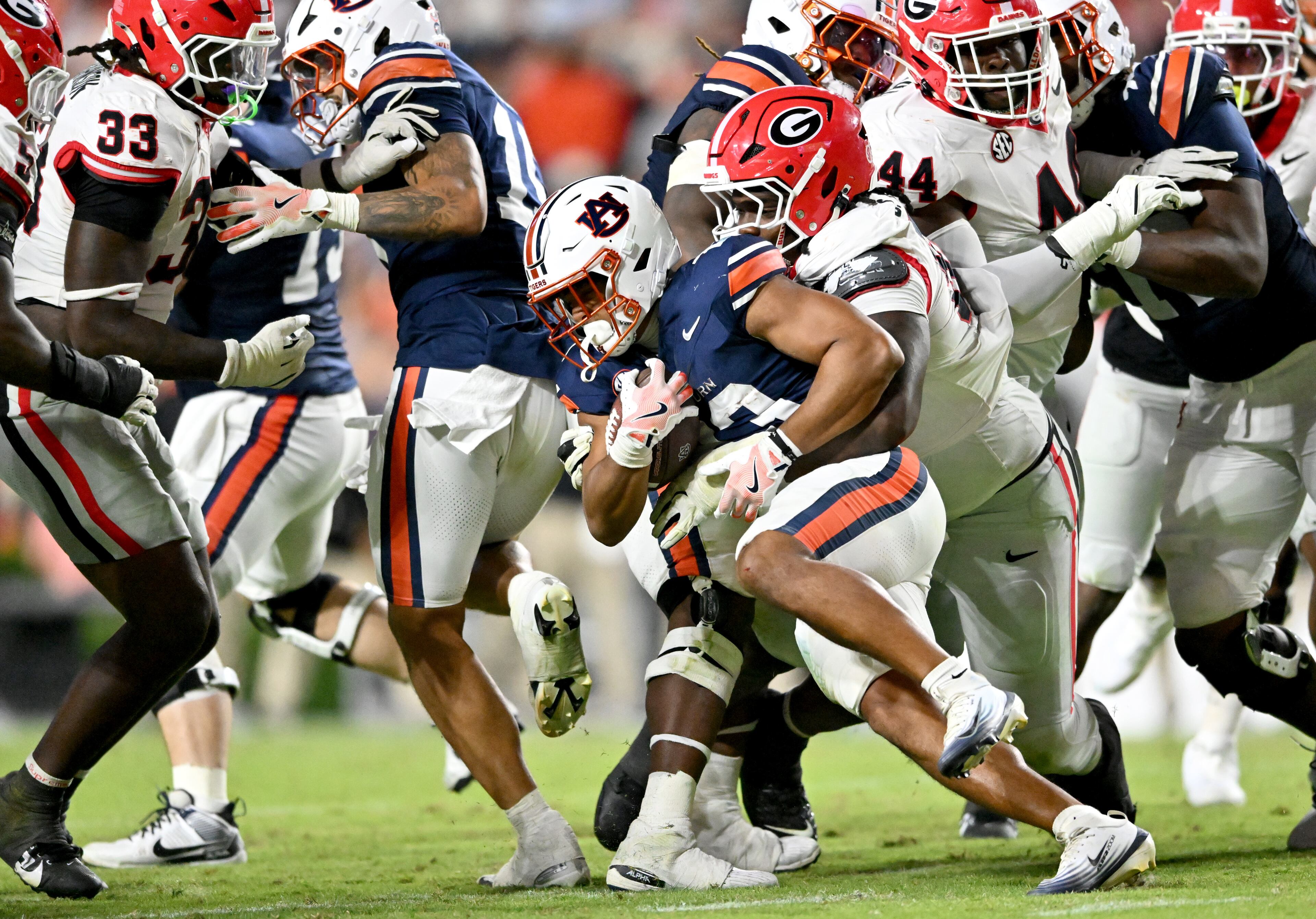 Auburn running back Jeremiah Cobb (23) gets tackled by Georgia defensive lineman Christen Miller (52) during the second half in a NCAA college football game at Jordan-Hare Stadium, Saturday, October 11, 2025, in Auburn, Ala. Georgia won 20-10 overAuburn. (Hyosub Shin / AJC)