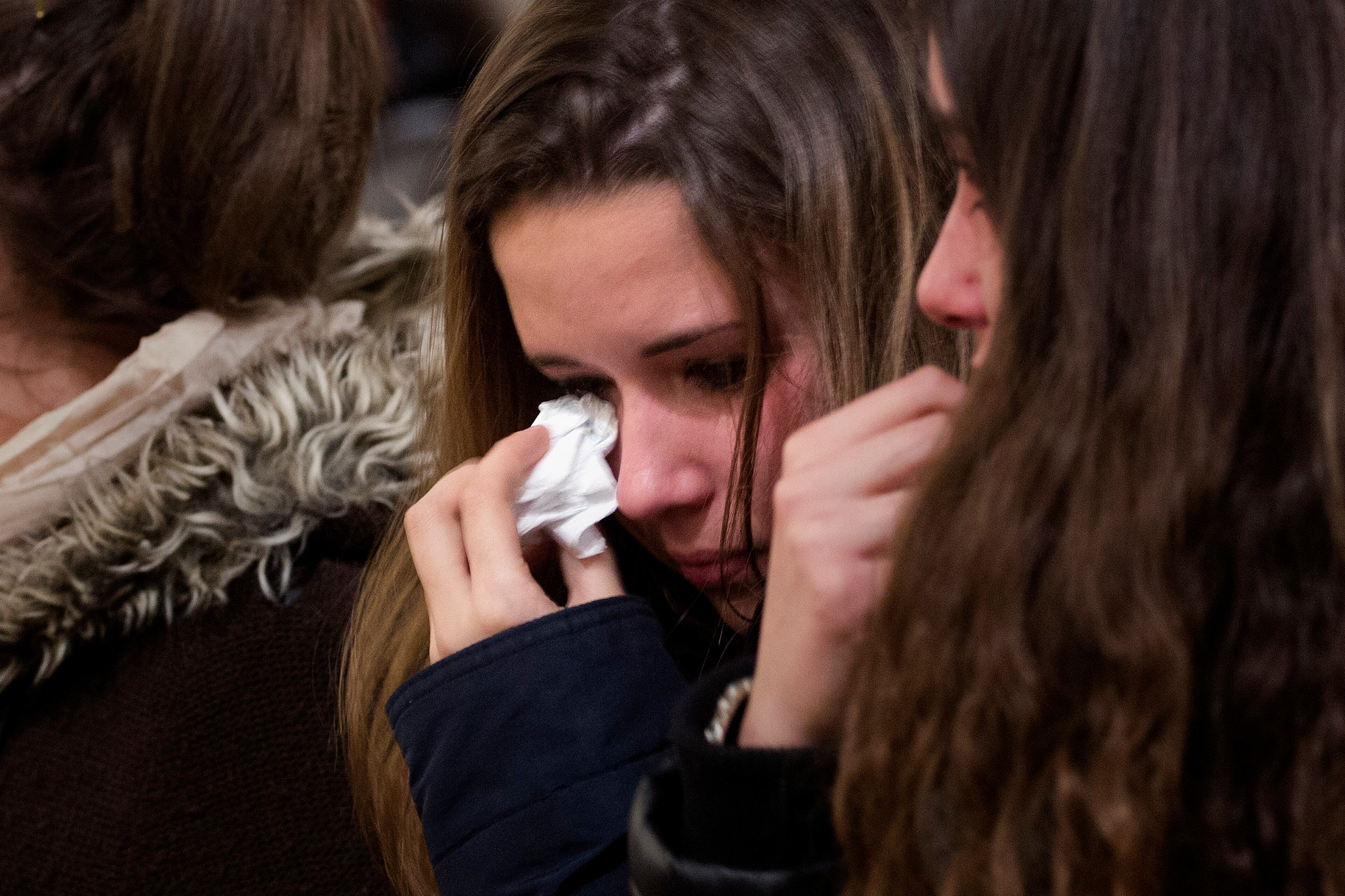A friend of the German students from the crashed plane, wipes away tears during a mass in Llinars del Valles, near Barcelona, Spain, Tuesday, March 24, 2015. Sixteen 10th-grade students from a town in western Germany and two of their teachers had just spent a week on an exchange near Barcelona and were less than an hour from landing when their Germanwings flight crashed in southern France. Officials confirmed Tuesday they were among the 150 people who died in the crash. (AP Photo/Emilio Morenatti)