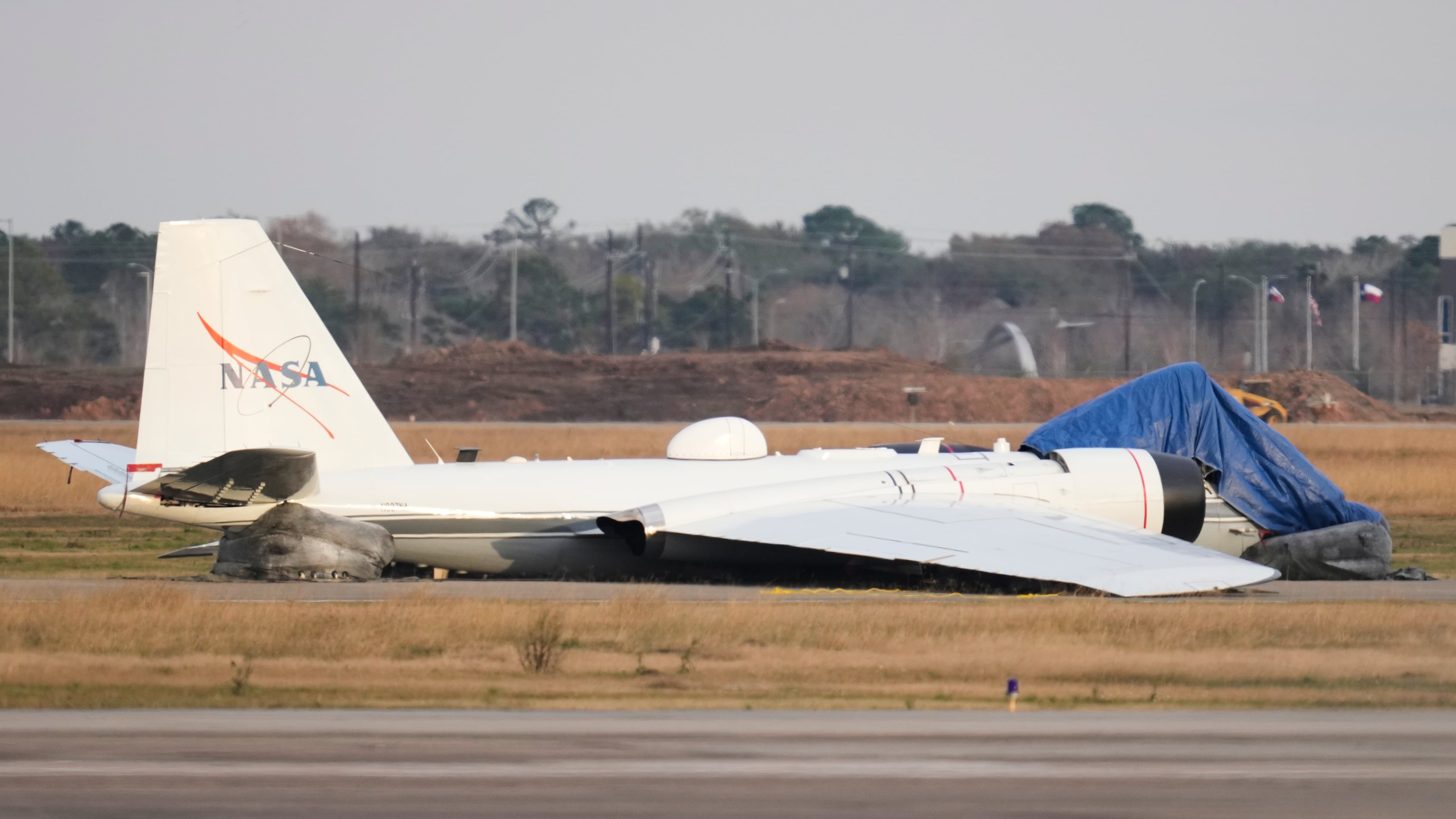 A NASA aircraft sits near a runway at Ellington Airport after making a belly landing on Tuesday, Jan. 27, 2026, in Houston. (AP Photo/Ashley Landis)
