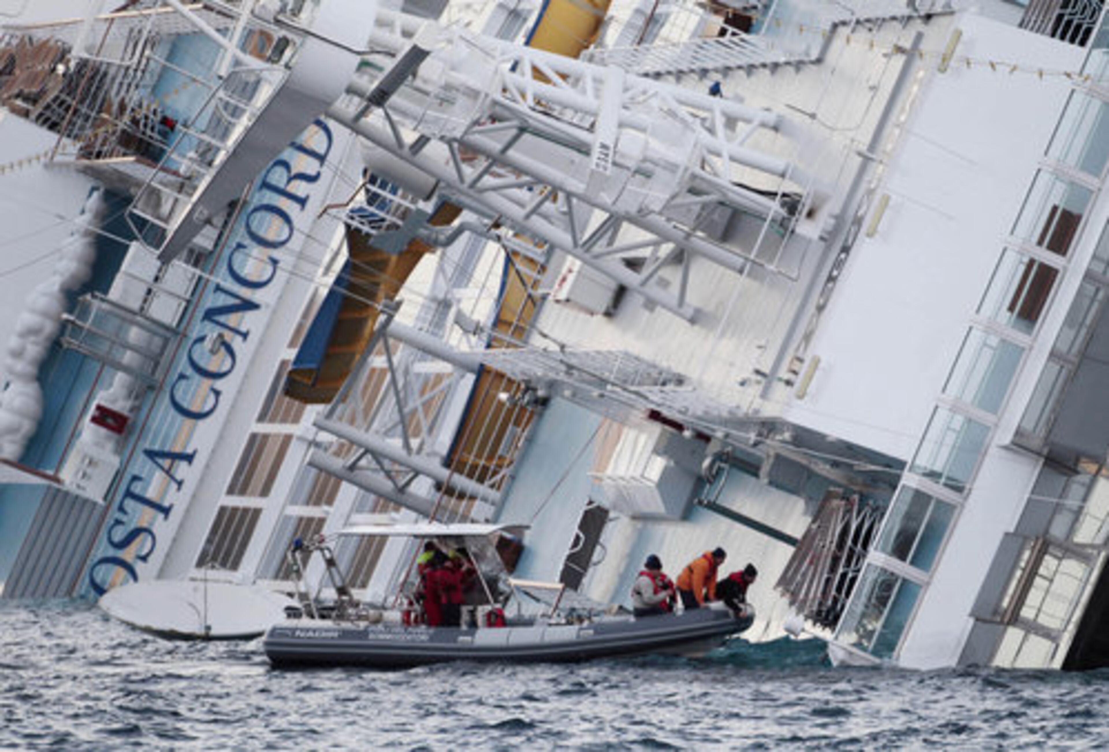 Italian firefighters' scuba divers approach the luxury cruise ship Costa Concordia which ran aground off the tiny Tuscan island of Giglio, Italy.