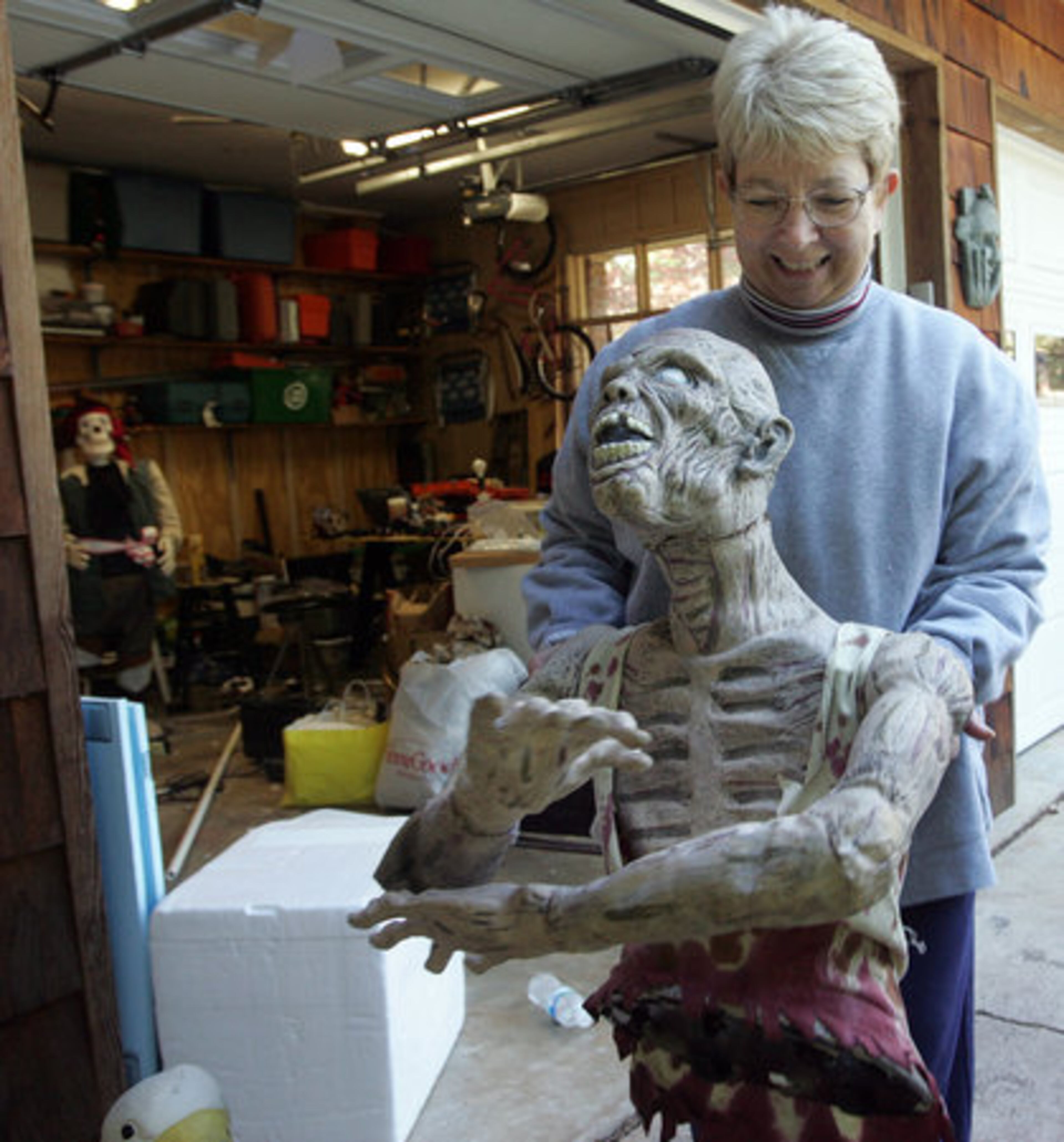 Now, some of Psathas' neighbors are starting to pitch in. Dee Roeske carries a mummy out of Psathas' garage for decorating.