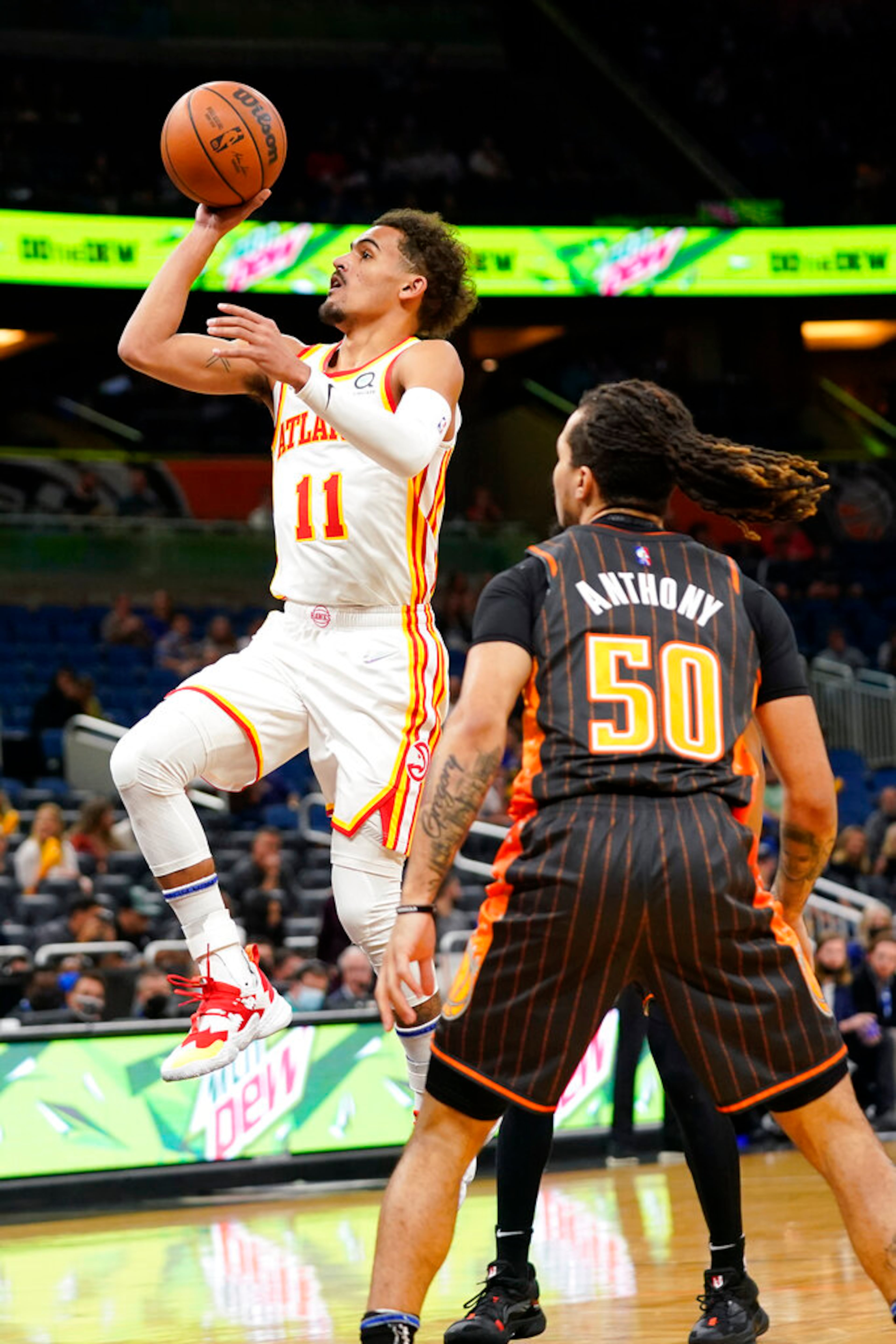 Atlanta Hawks guard Trae Young (11) takes a shot as he get past Orlando Magic guard Cole Anthony (50) during the first half of an NBA basketball game, Wednesday, Dec. 15, 2021, in Orlando, Fla. (AP Photo/John Raoux)