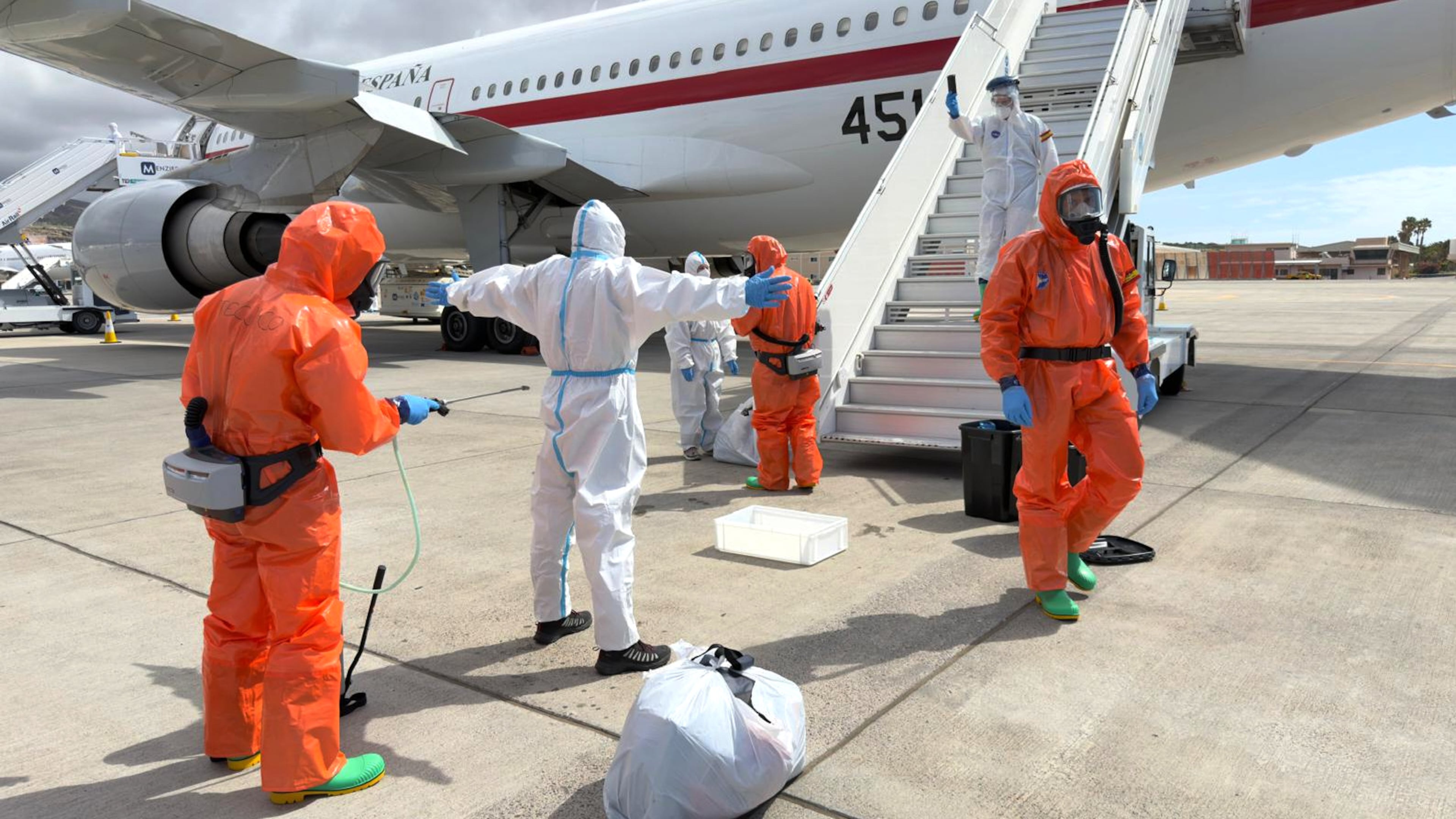 A Spanish passenger is sprayed with disinfectant by Spanish government officials before boarding a plane after disembarking from the hantavirus-stricken cruise ship MV Hondius at Tenerife airport in the Canary Islands, Spain, Sunday, May 10, 2026. (AP Photo)