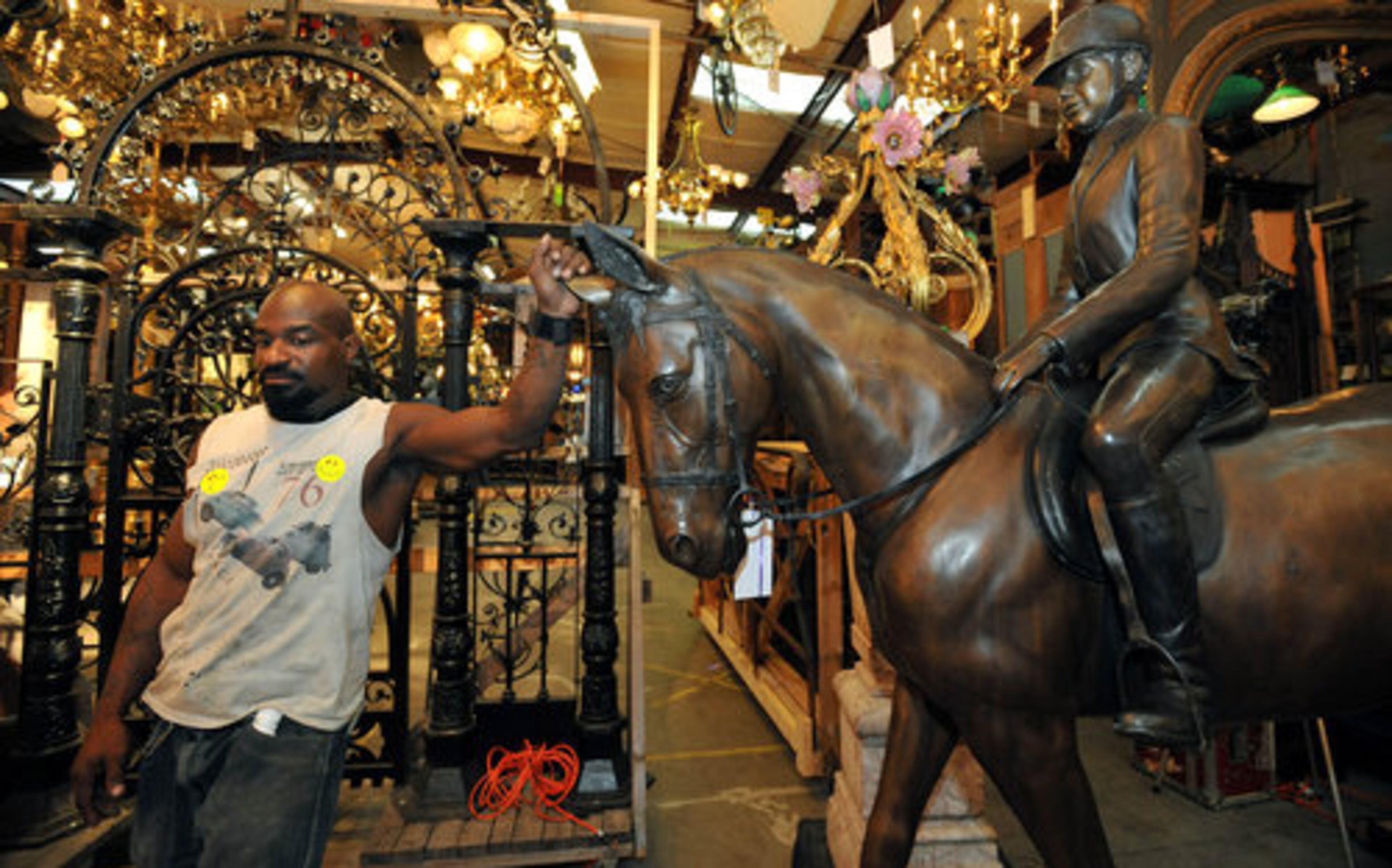 Charles Linton stands next to a bronze horse and rider as he prepares for its display for bidders.