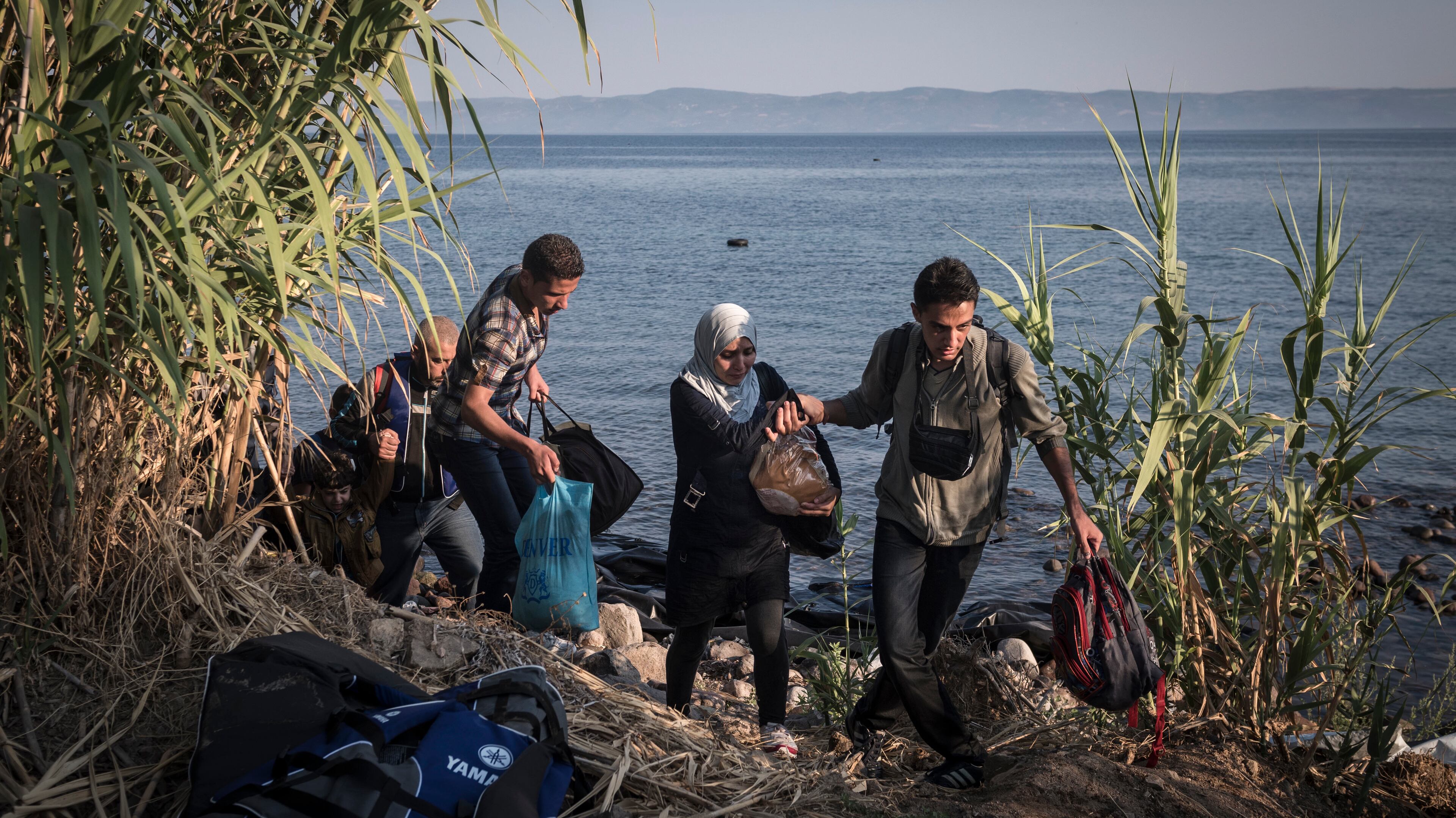 Syrian migrants walk from their landing site toward police authorities after arriving in Lesbos, Greece. Sergey Ponomarev/The New York Times file