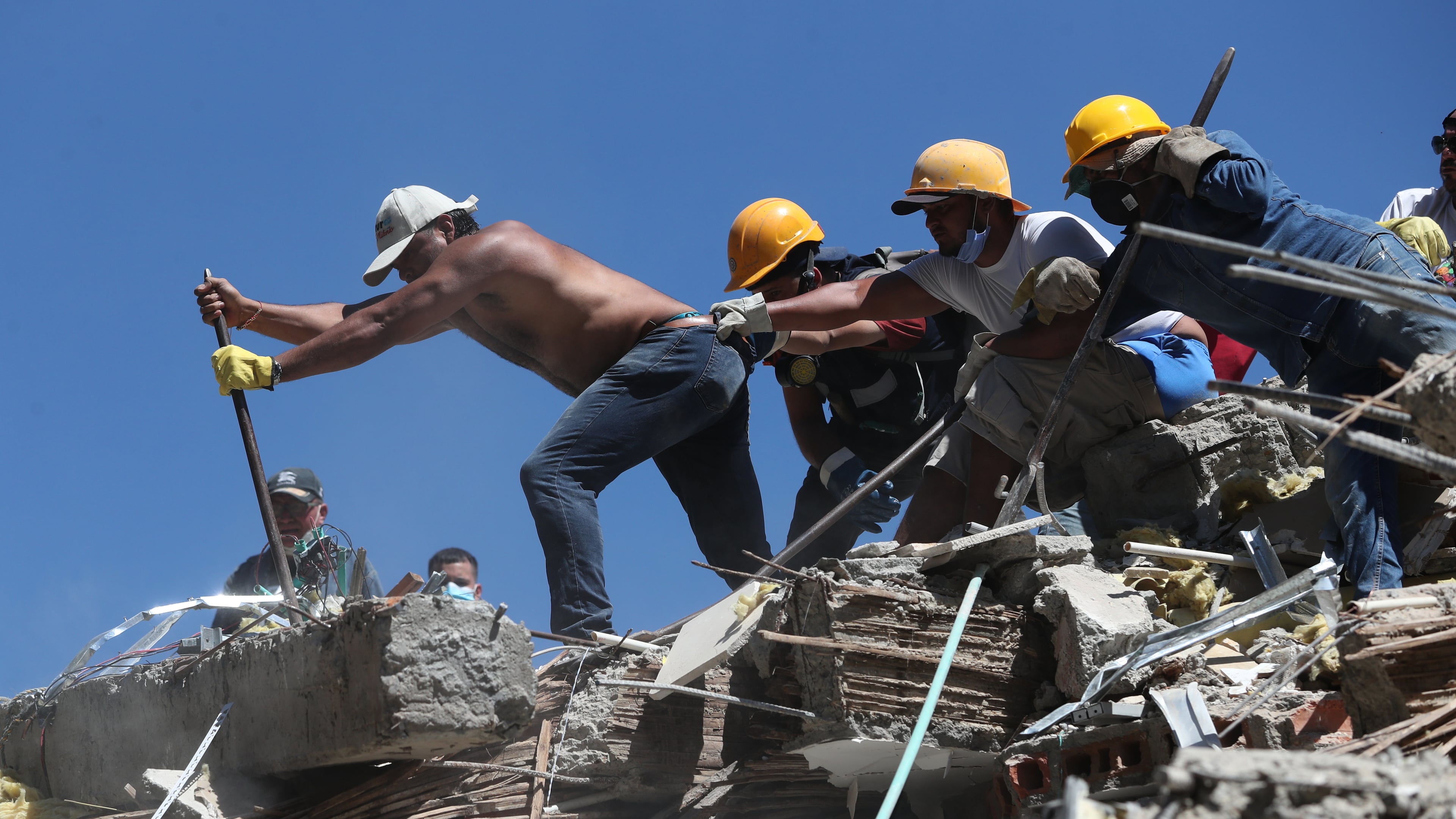 Residents and rescue workers search through the rubble after an earthquake struck Cali, Colombia, Monday, Aug. 10, 2026. (AP Photo/Santiago Saldarriaga)