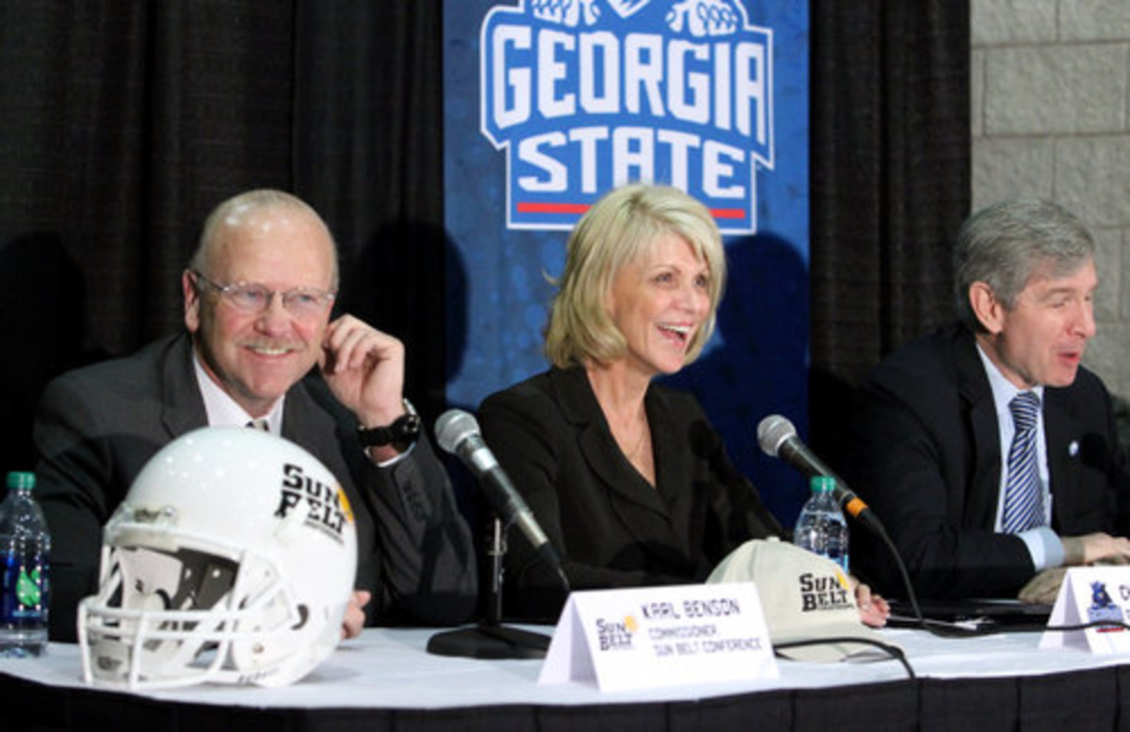 Sun Belt Conference Commissioner Karl Benson, left, Georgia State University Director of Athletics Cheryl L. Levick, center, and Georgia State University President Mark Becker, right, laugh as they announce plans for GSU to join the Sun Belt Conference in 2013 at the Georgia Dome Monday afternoon in Atlanta, Ga., April 9, 2012.