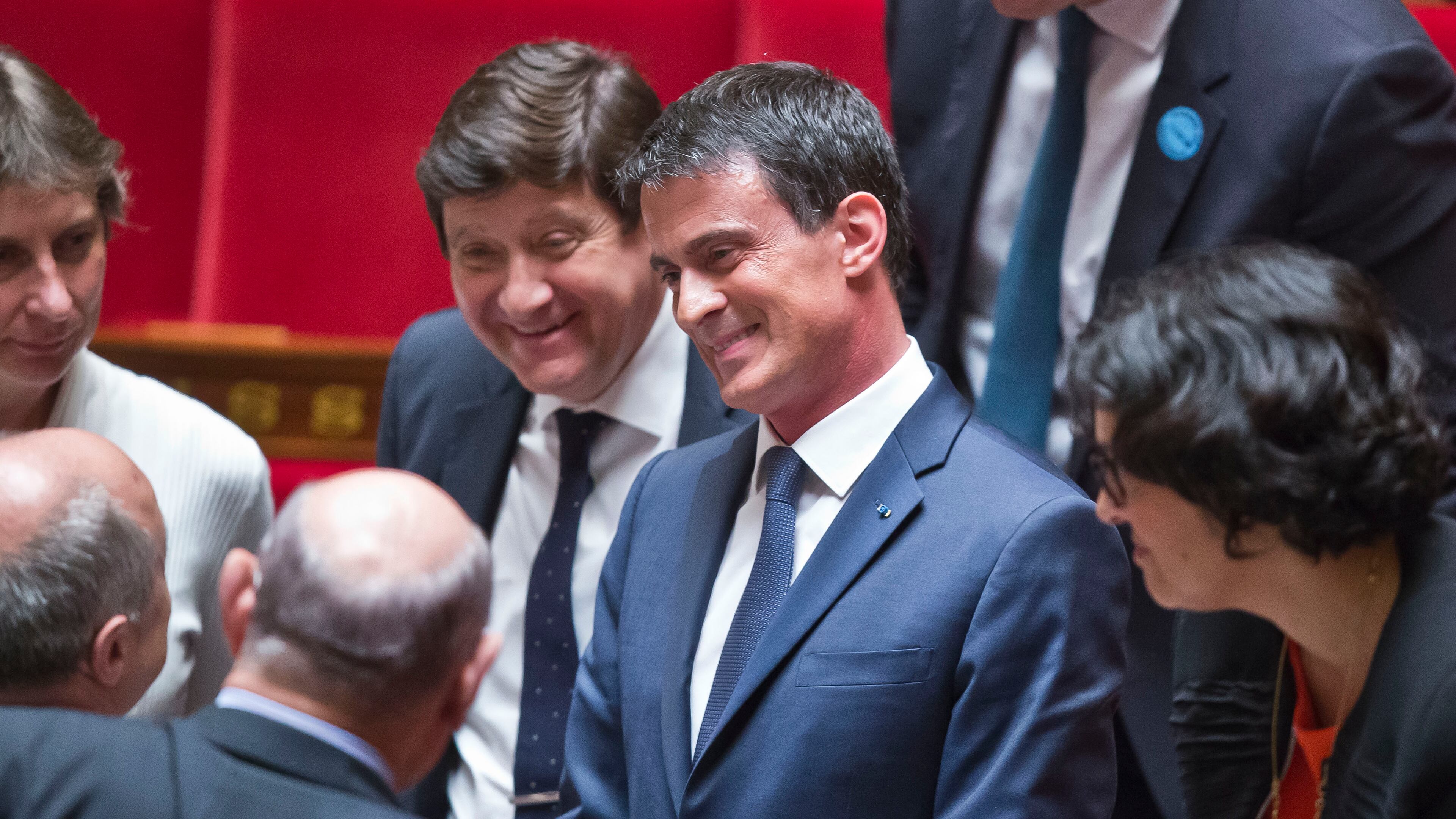 French Prime Minister Manuel Valls is surrounded by members of the parliament after his speech during the labor law debate at the national assembly in Paris, France, Thursday, May 12, 2016. France's government is facing a major test as lawmakers hold a no-confidence vote, prompted by a deeply divisive labor law allowing longer workdays and easier layoffs. (AP Photo/Michel Euler)