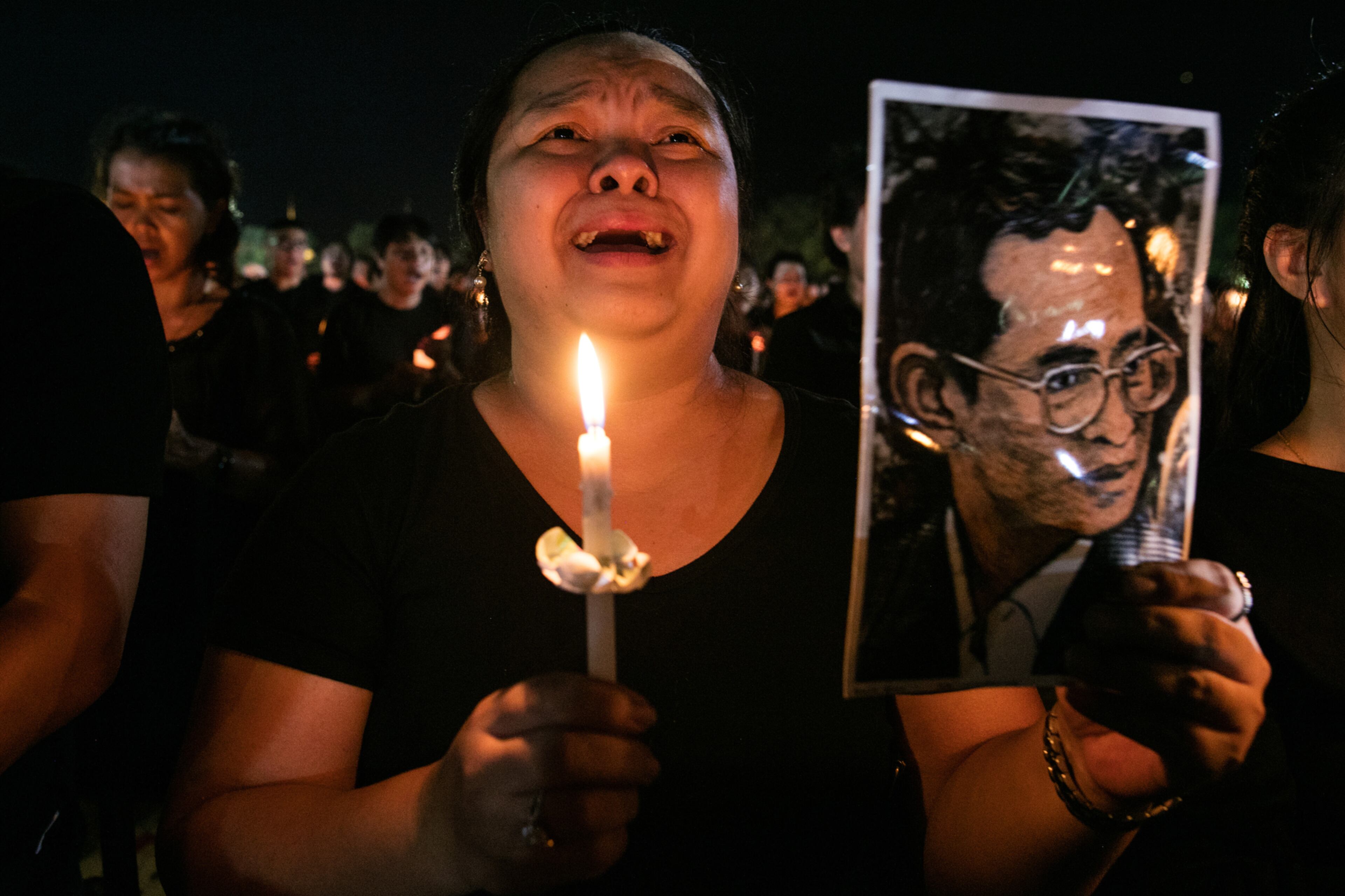 BANGKOK, THAILAND - OCTOBER 22: Bonskot Chaisuwan cries as she joins everyone in singing the Royal anthem on October 22, 2016 in Bangkok, Thailand. Tens of thousands attended the emotional event which was filmed paying tribute to Thailand's King Bhumibol Adulyadej, the world's longest-reigning monarch, died at the age of 88 after his 70-year reign. The Crown Prince Maha Vajiralongkorn had asked for time to grieve the loss of his father before becoming the next king as nation waits for the coronation date. (Photo by Paula Bronstein/Getty Images) *** BESTPIX ***
