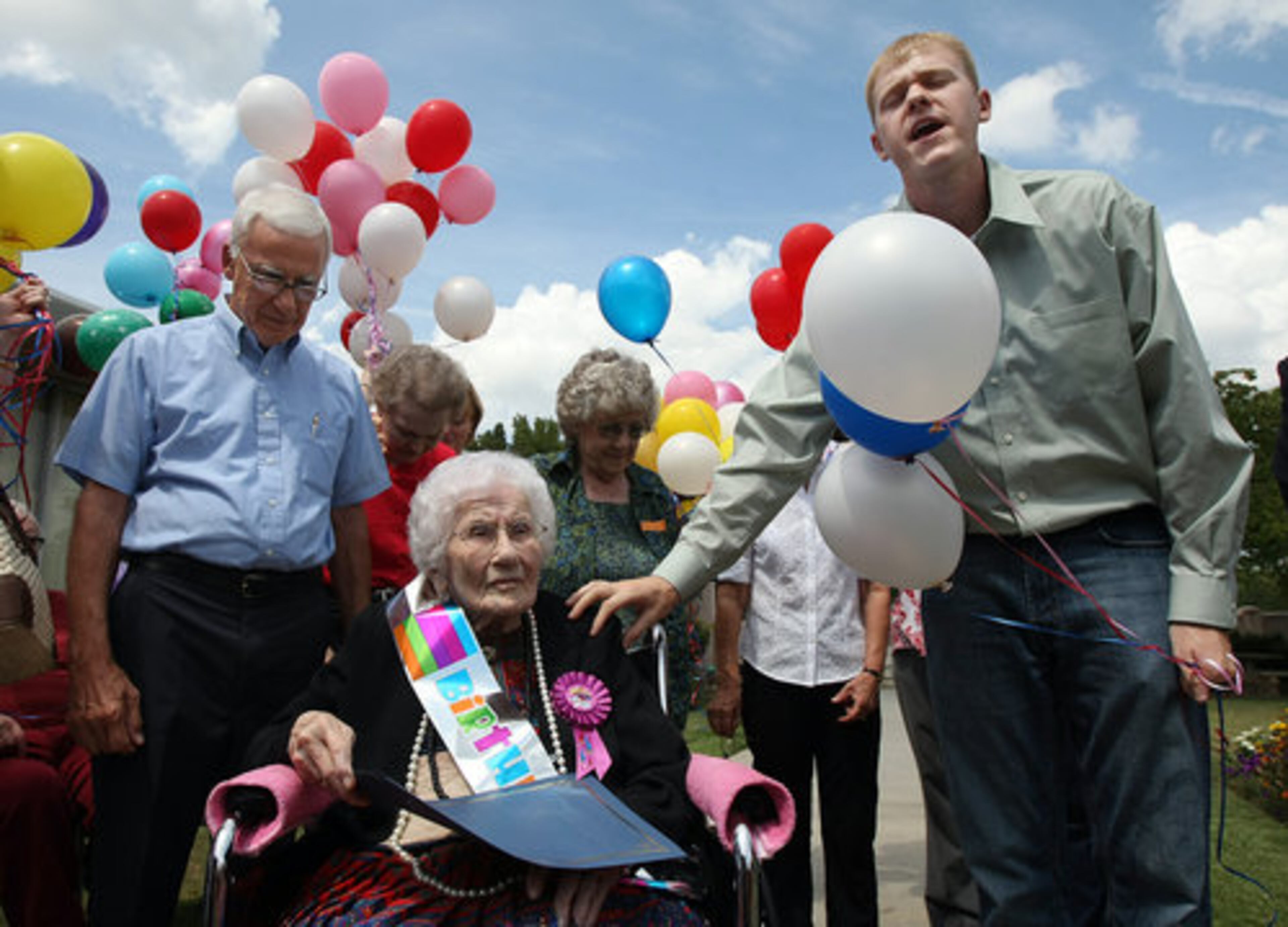 Rev. Andrew Erwin, right, New Hope At Between United Methodist, delivers a prayer for Besse Cooper, at her birthday celebration.