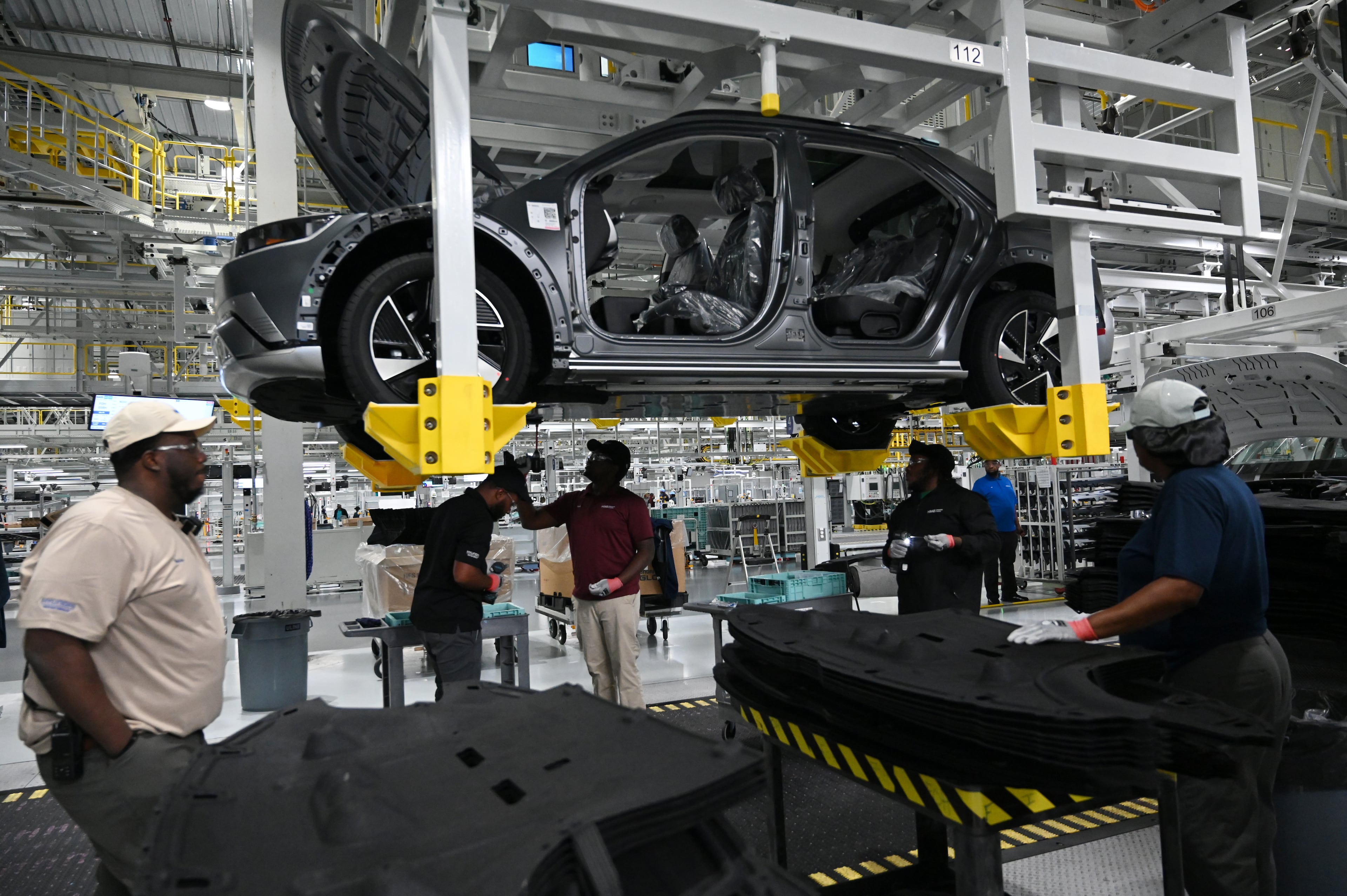 HMGMA workers check a Hyundai IONIQ 5 on the assembly line at Hyundai Motor Group Metaplant America (HMGMA) in Ellabell on Wednesday, May 6, 2026. (Hyosub Shin/AJC)