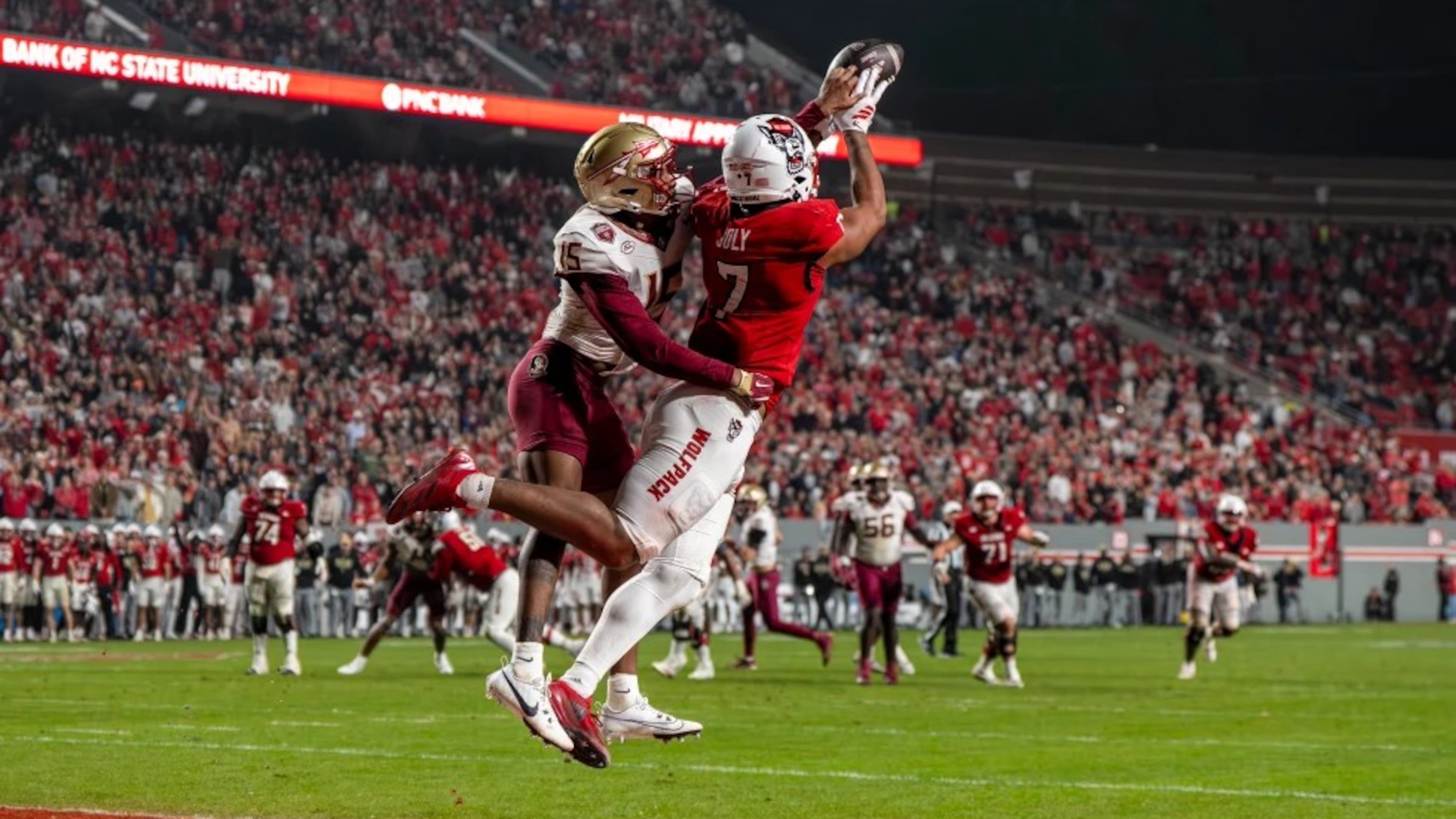 N.C. State tight end Justin Joly (7) soars to make a catch over Florida State defensive back Shamar Arnoux (15) in the second half of a NCAA football game on Nov. 21, 2025. (David Yeazell/AP)