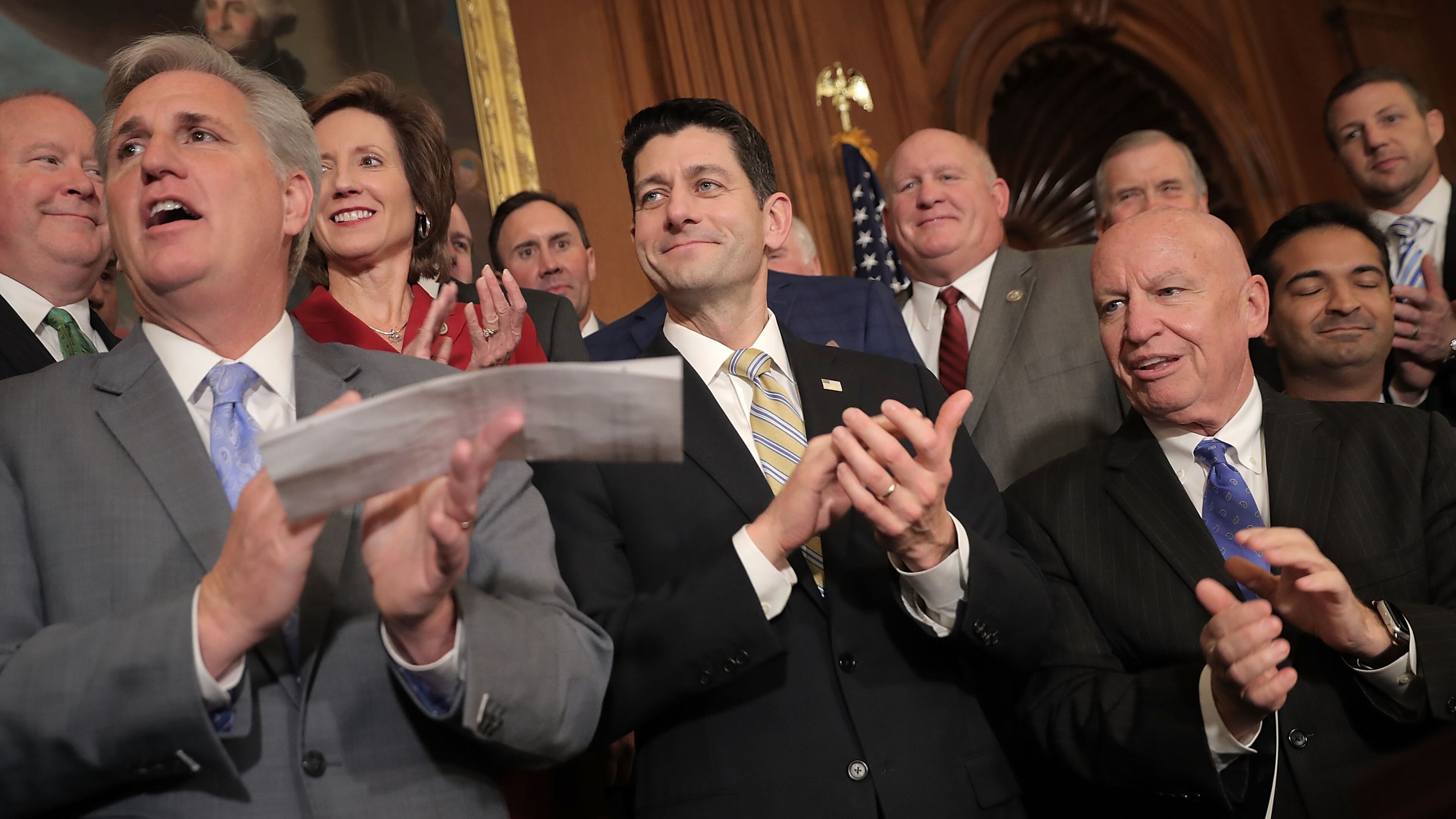 House Majority Leader Kevin McCarthy (R-CA), Speaker of the House Paul Ryan (R-WI) and House Ways and Means Committee Chairman Kevin Brady (R-TX) applaud with their fellow House Republicans during a news conference following the passage of the Tax Cuts and Jobs Act, Thursday. (Chip Somodevilla / Getty Images)