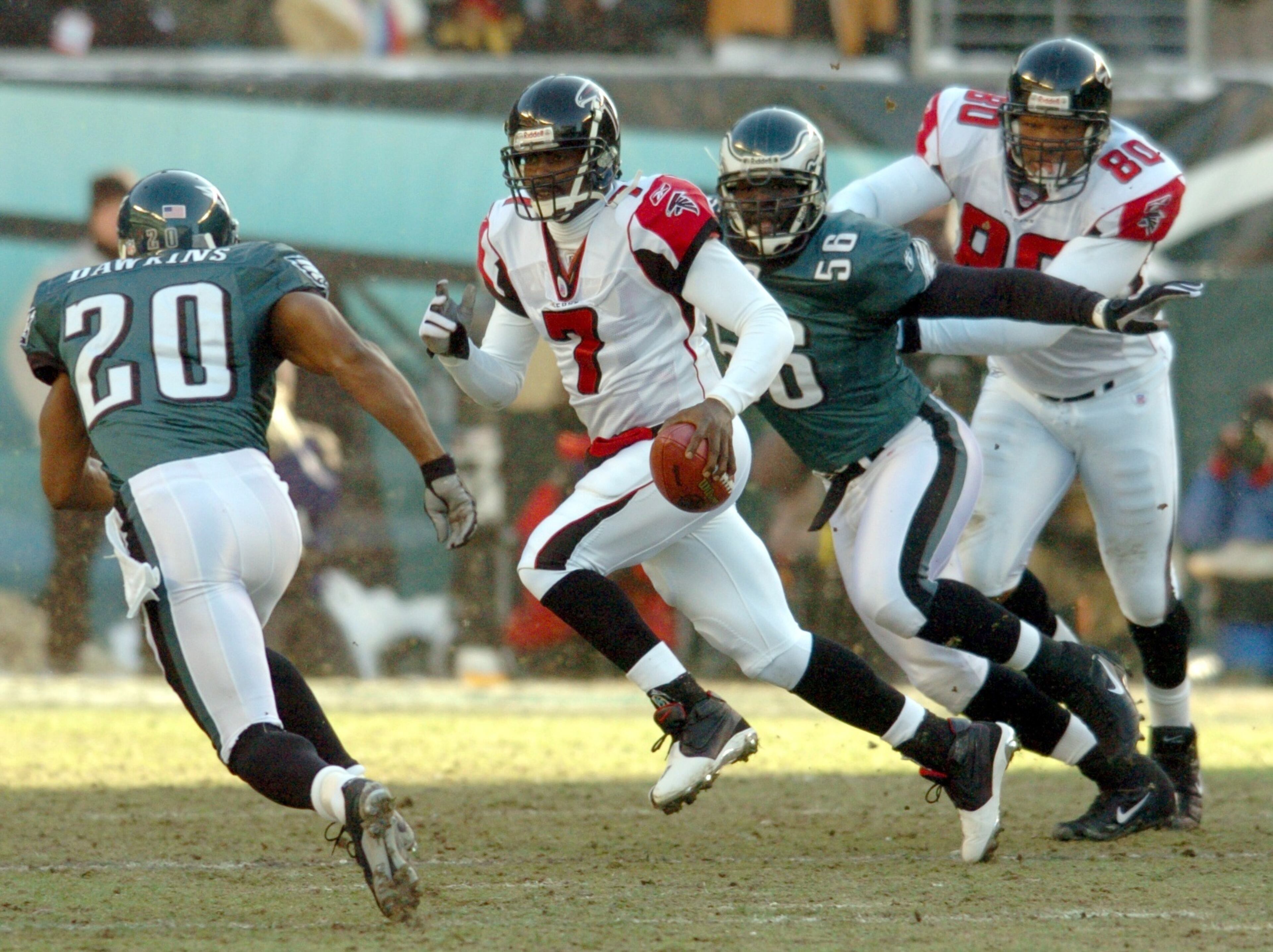 Falcons quarterback Mike Vick scrambles upfield for a long run under pursuit by Eagles Brian Dawkins (20) and Derrick Burgess (56) while Falcons' end Eric Beverly (80) makes the block in the backfield in the first quarter of the NFC Championship game at Lincoln Financial Field on Sunday, January 23, 2005. (CURTIS COMPTON/AJC staff)
