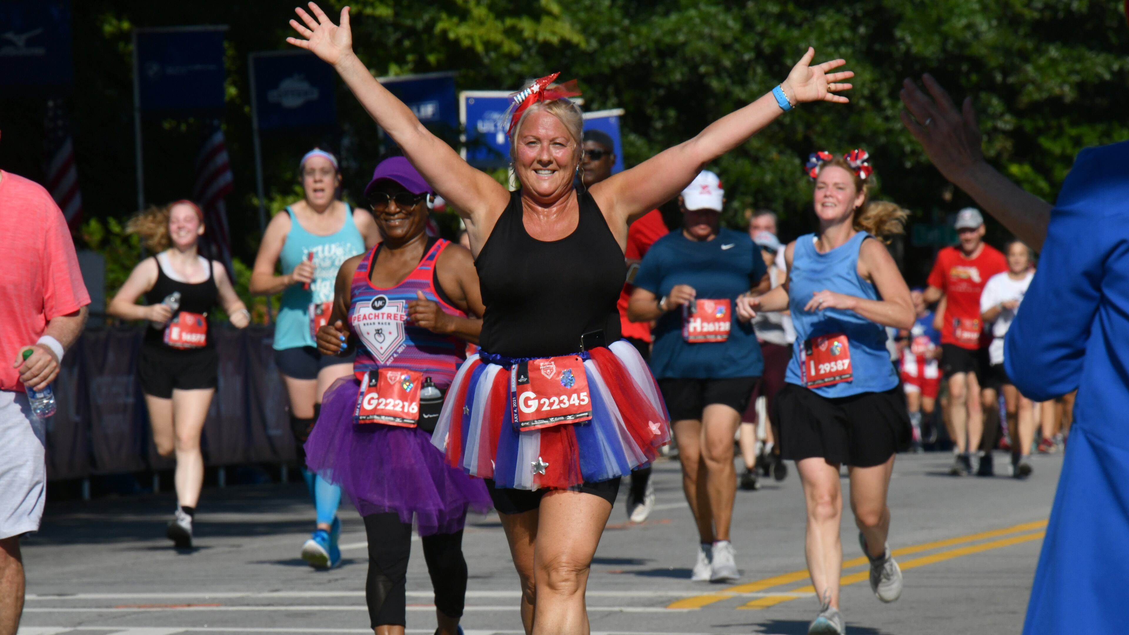 July 4, 2021 Atlanta - Runners make their way to cross the finish line during the second day of 2021 Atlanta Journal-Constitution Peachtree Road Race on Sunday, July 4, 2021. (Hyosub Shin / Hyosub.Shin@ajc.com)