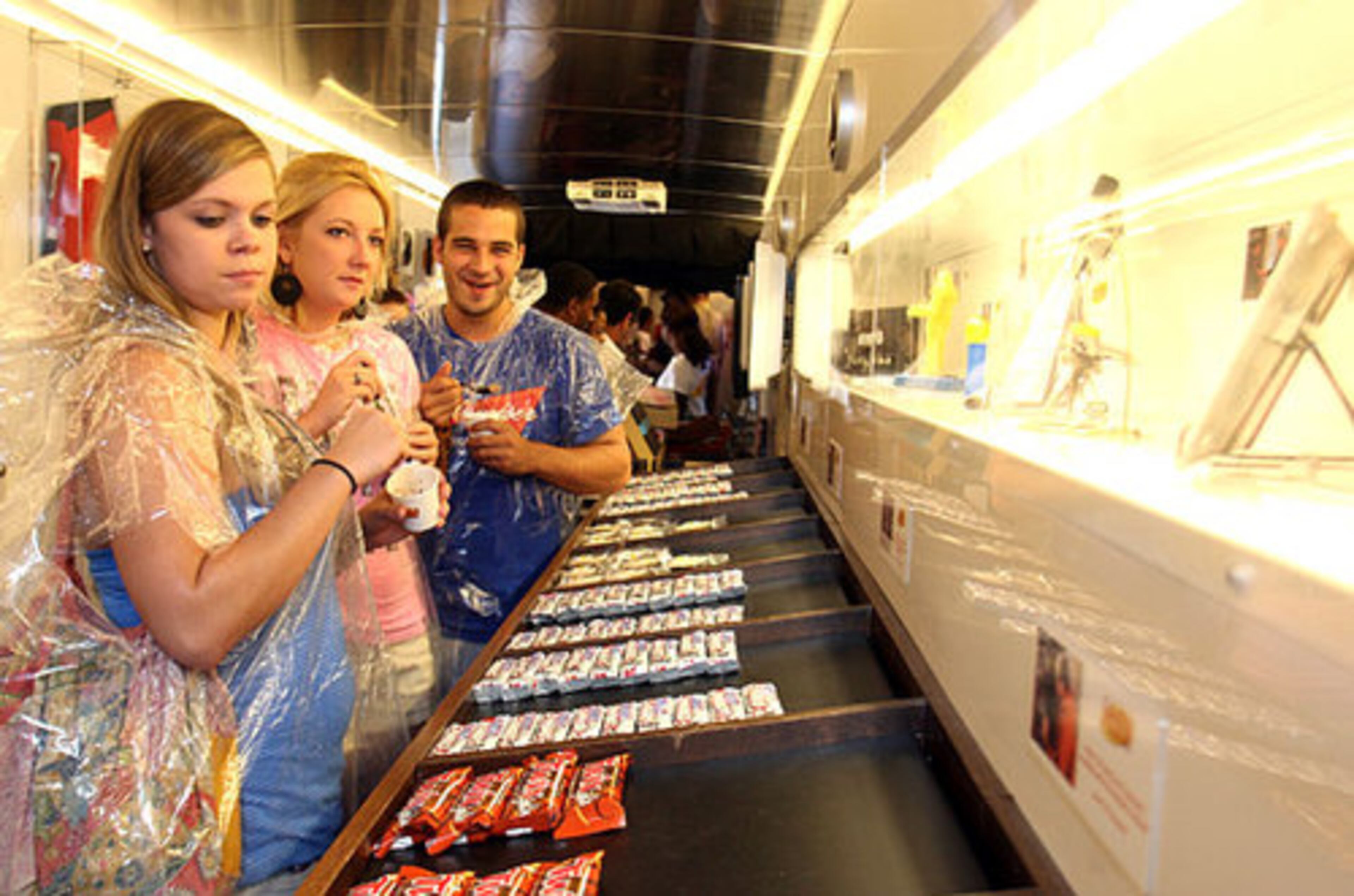 Linda Jackson, left,19, Kristin Tunstall, 20, and Riley Johnson, 19, all of Charleston, S.C., look at Seinfled memorabilia and candy displayed inside the Seinfeld bus. The three teenagers are all familiar with the show.