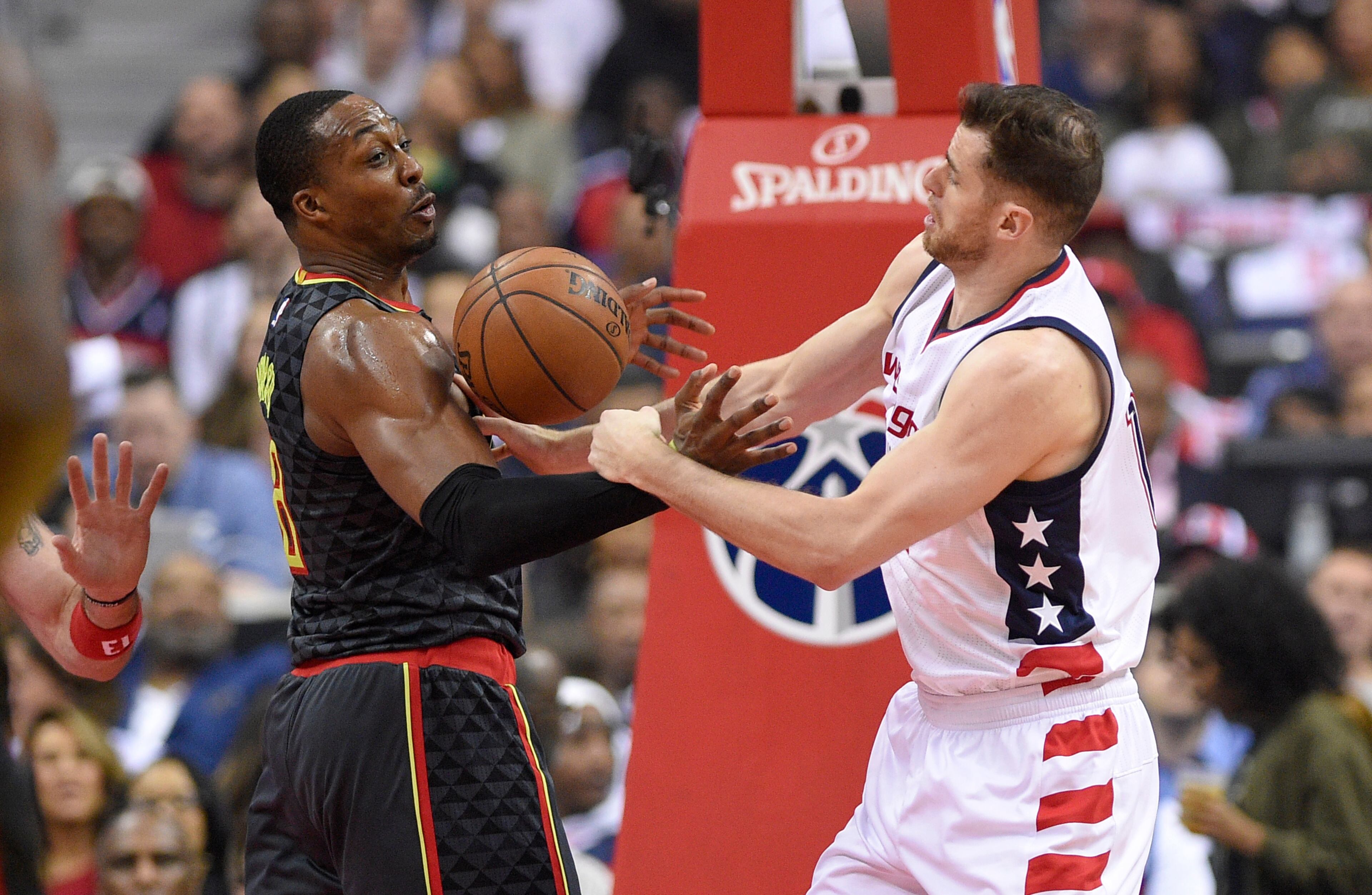 Washington Wizards forward Jason Smith, right, and Atlanta Hawks center Dwight Howard, left, reach for the ball during the first half in Game 2 of a first-round NBA basketball playoff series, Wednesday, April 19, 2017, in Washington. (AP Photo/Nick Wass)
